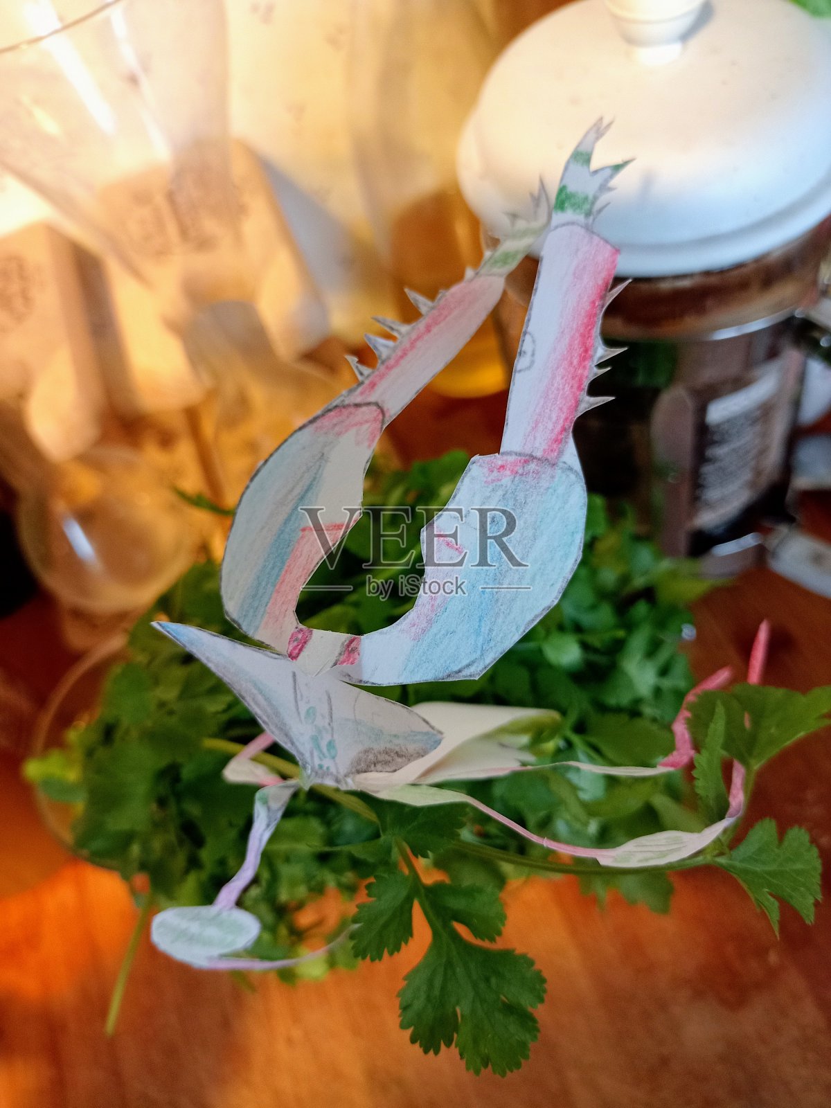 一个邪恶的螳螂在恐吓姿势的微缩照片在剪纸和彩色纸躺在欧芹在厨房照片摄影图片