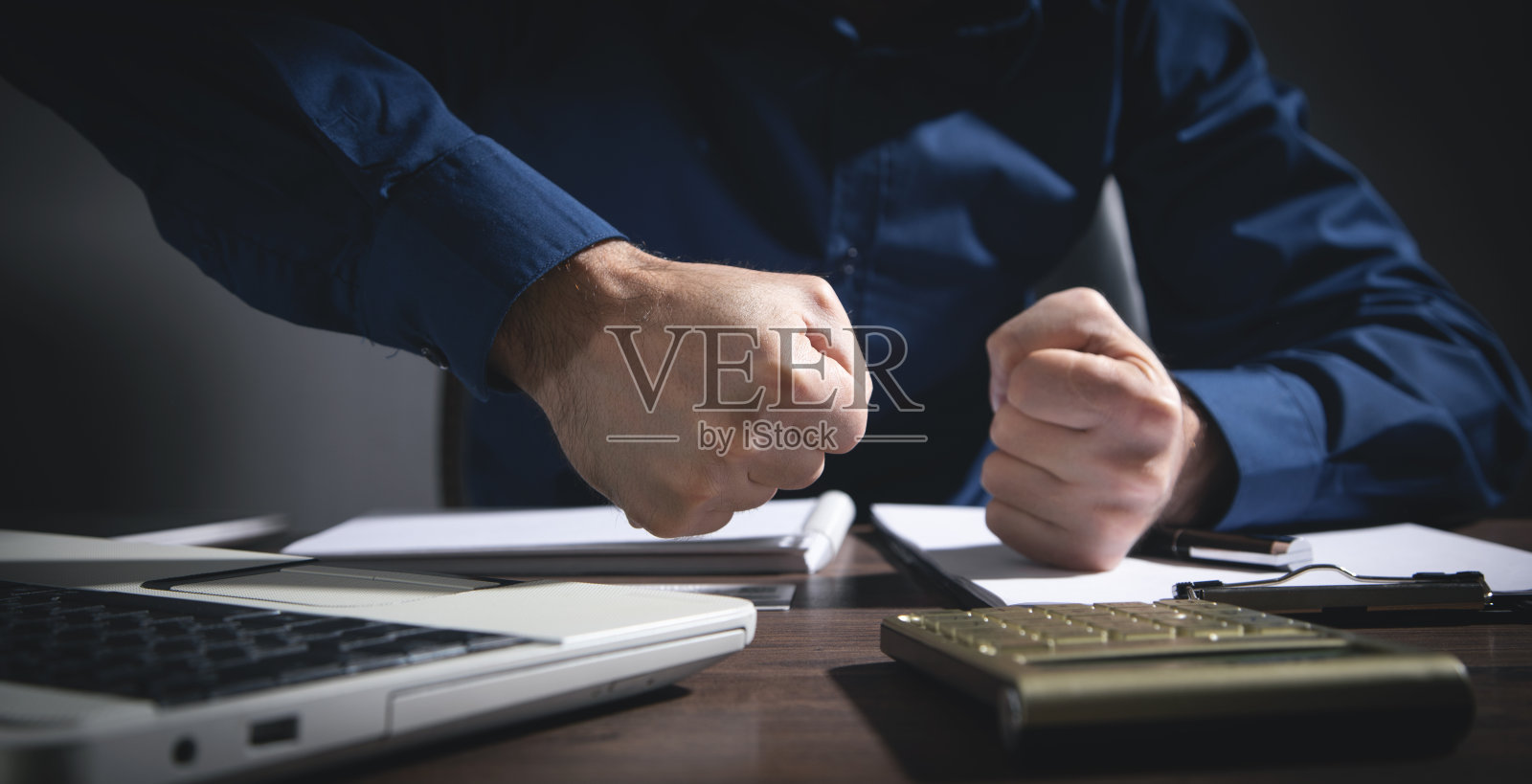 愤怒的商人挥舞着拳头。照片摄影图片