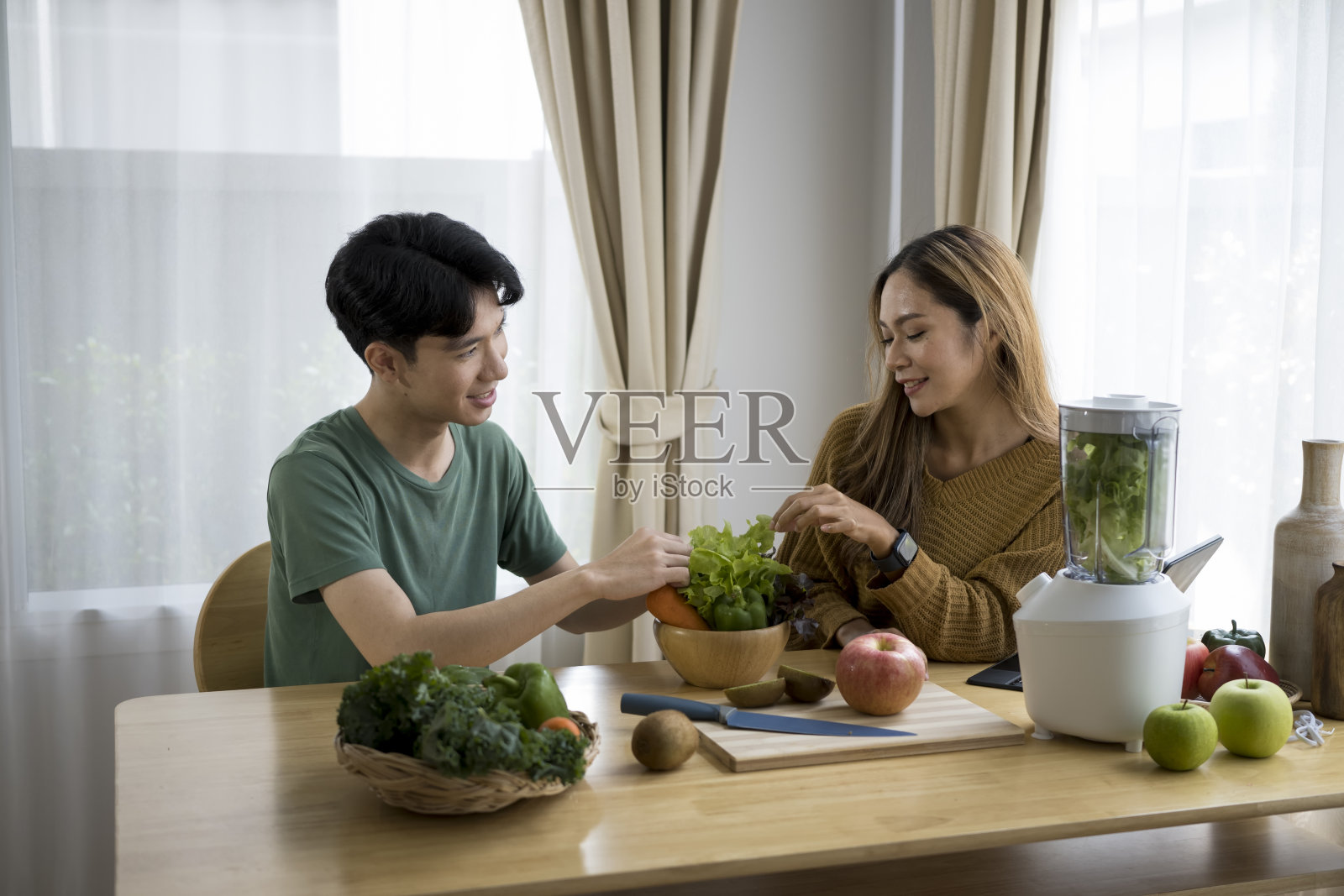 年轻健康的亚洲夫妇一起在厨房准备健康的食物。照片摄影图片