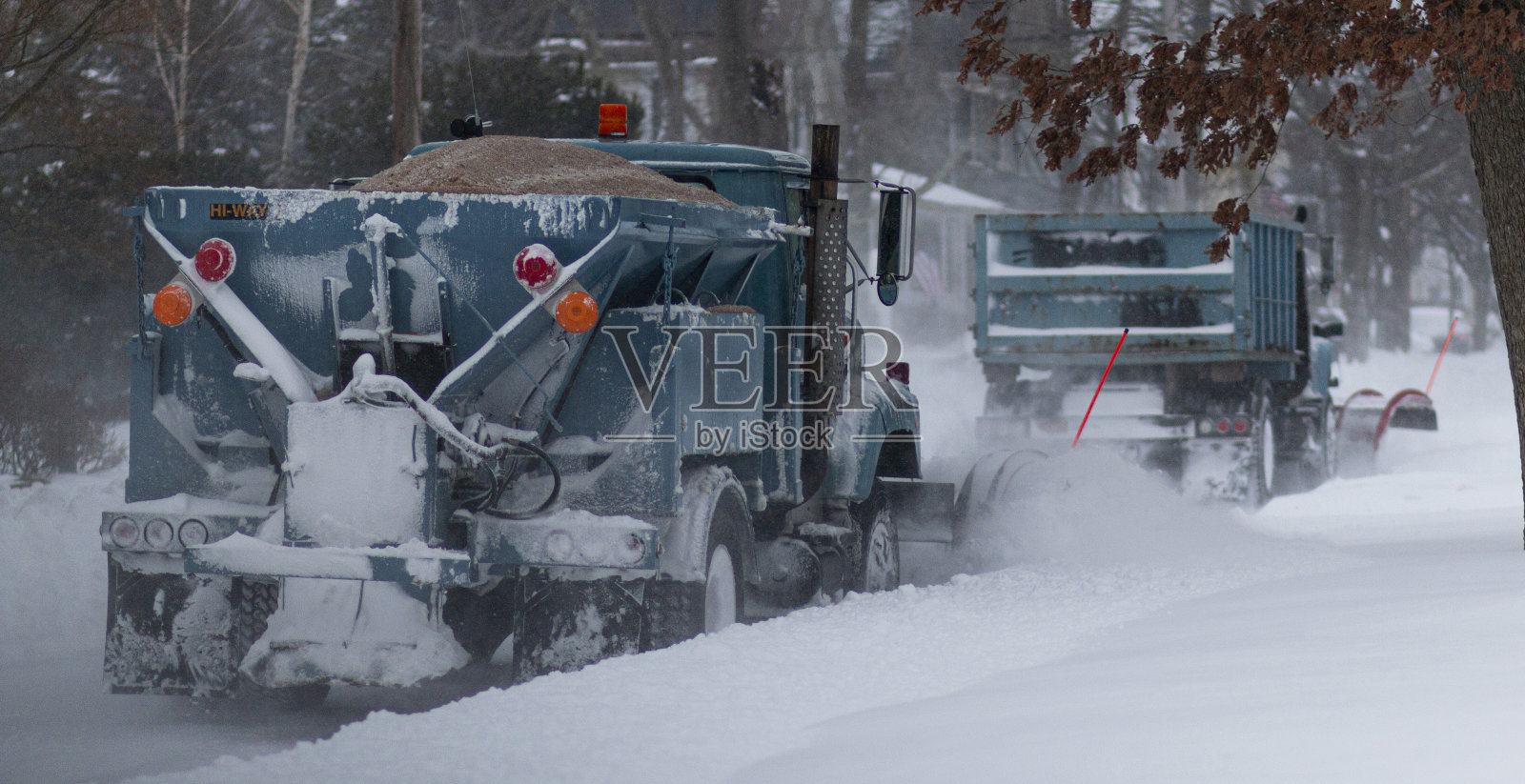 长岛一场暴风雪中,两辆扫雪车正在清理住宅区的街道照片摄影图片