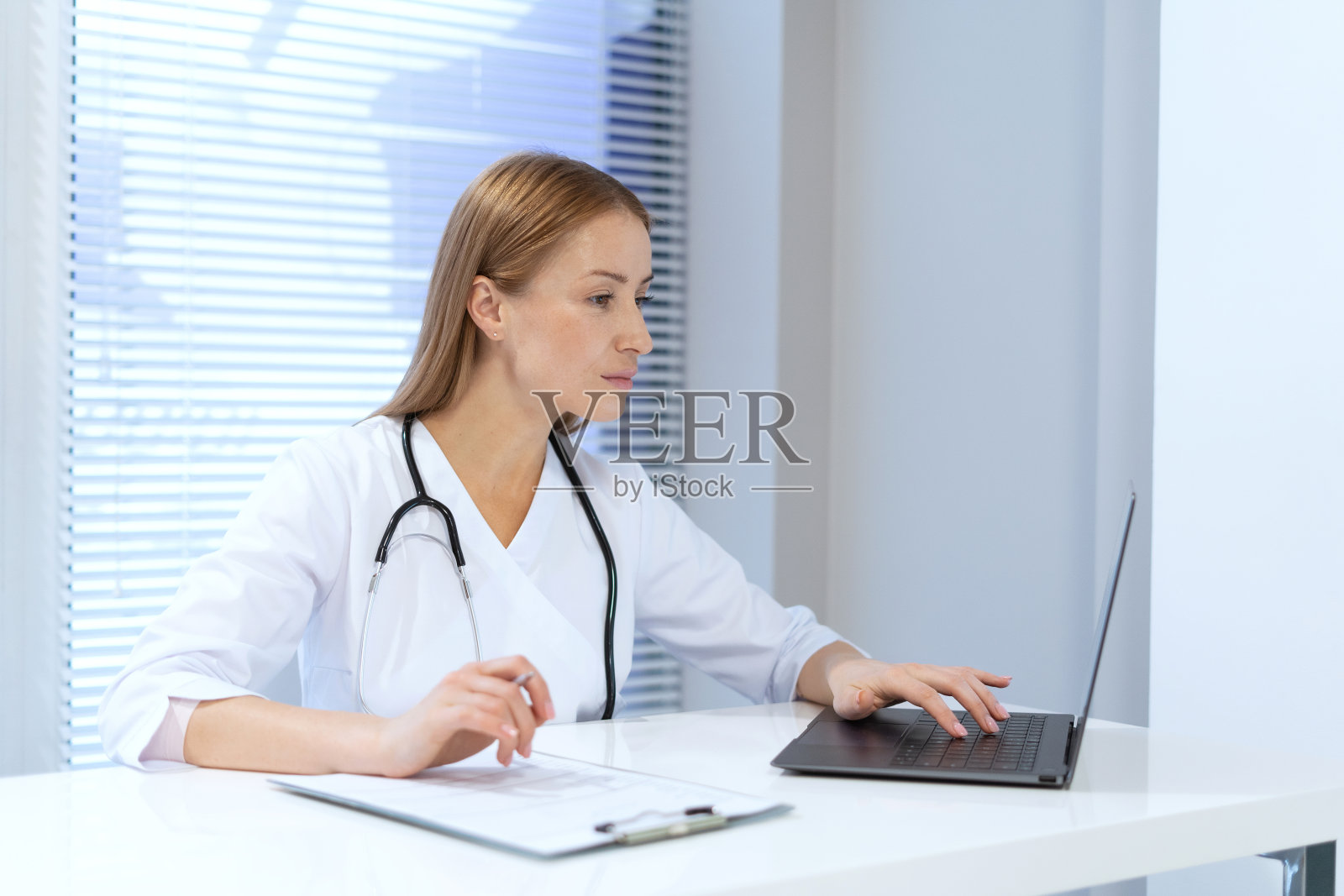 家庭医生在诊所使用笔记本电脑照片摄影图片