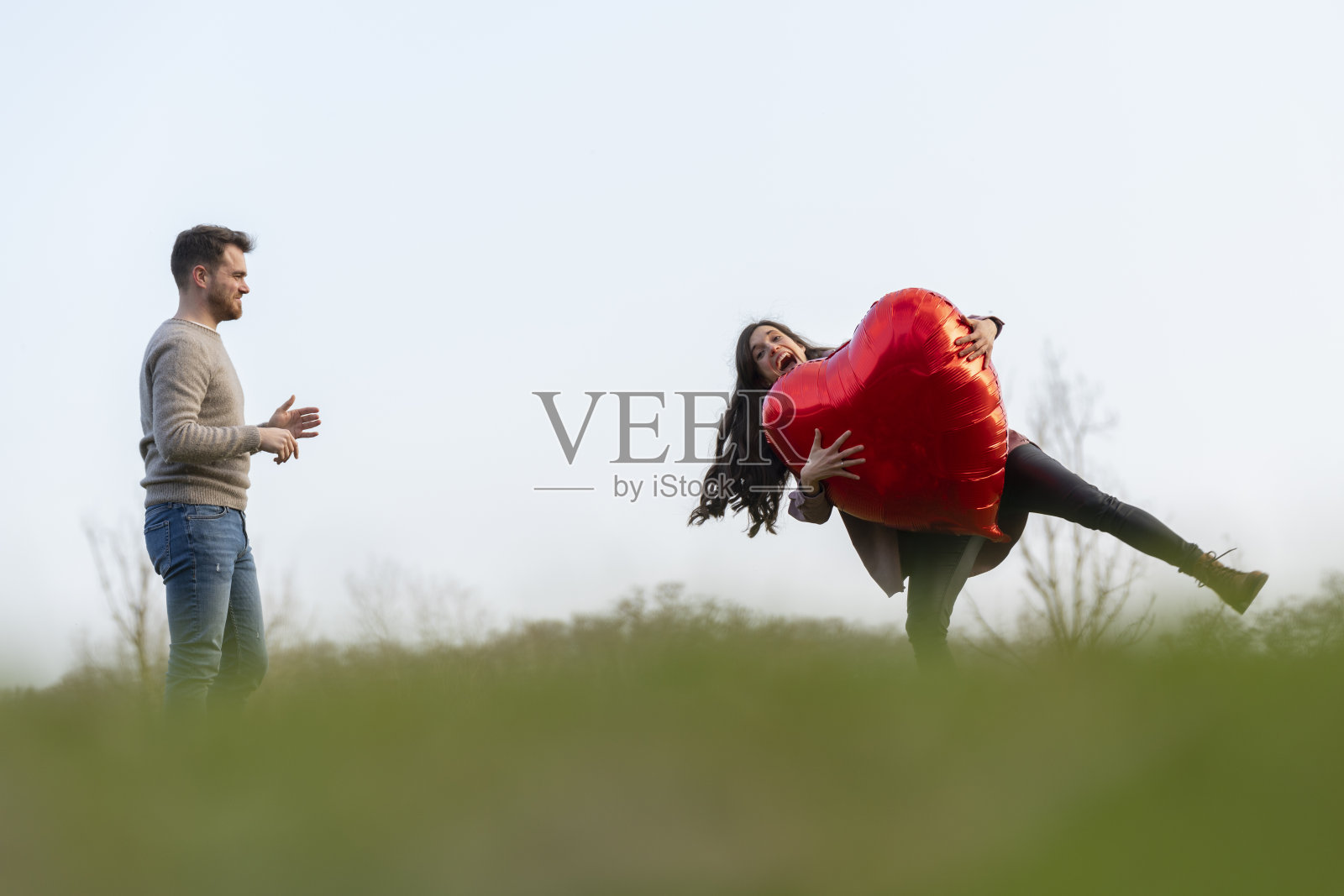 年轻情侣玩心形气球庆祝情人节照片摄影图片