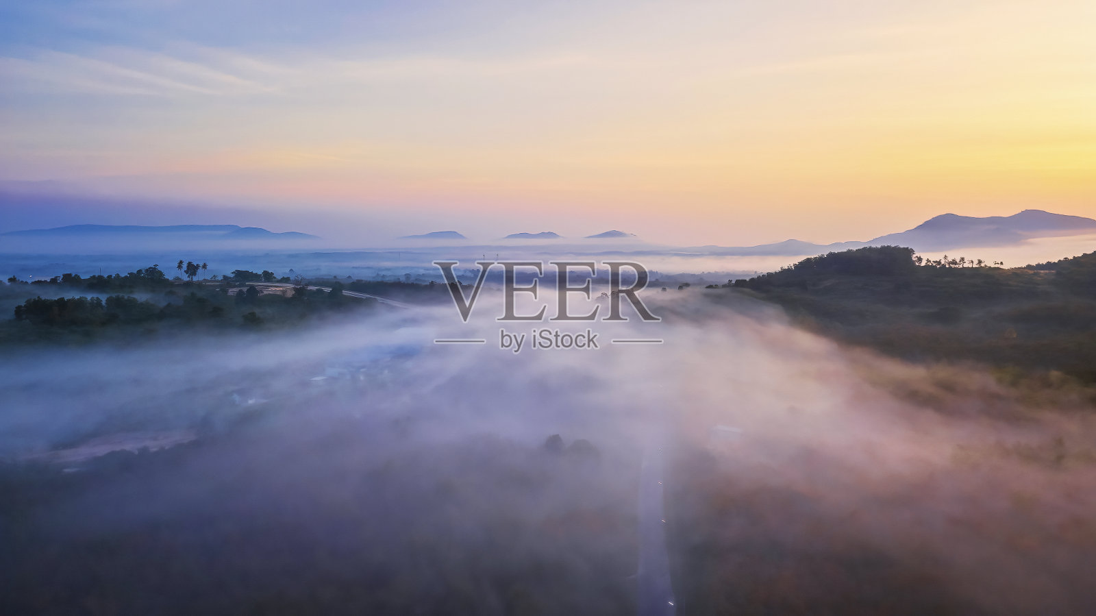 鸟瞰图从雾的无人机在森林道路在日出照片摄影图片