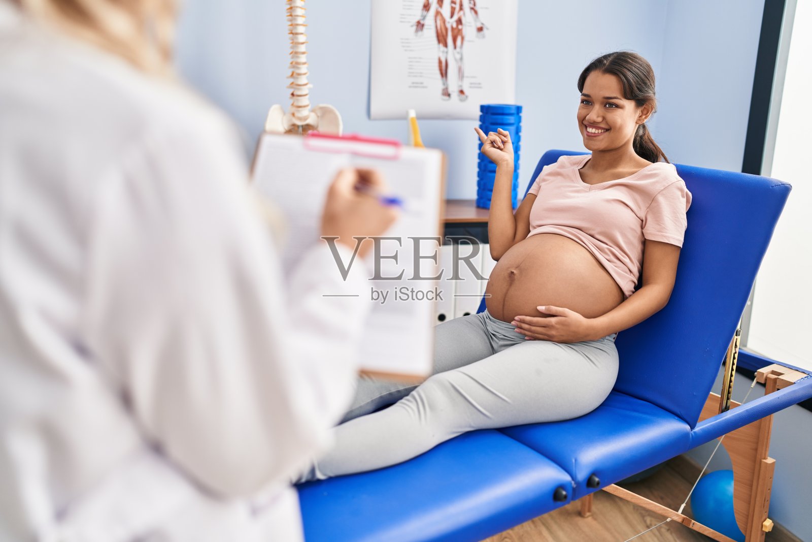 年轻的孕妇在理疗诊所愤怒和疯狂的尖叫沮丧和愤怒,呼喊着愤怒的抬头。照片摄影图片