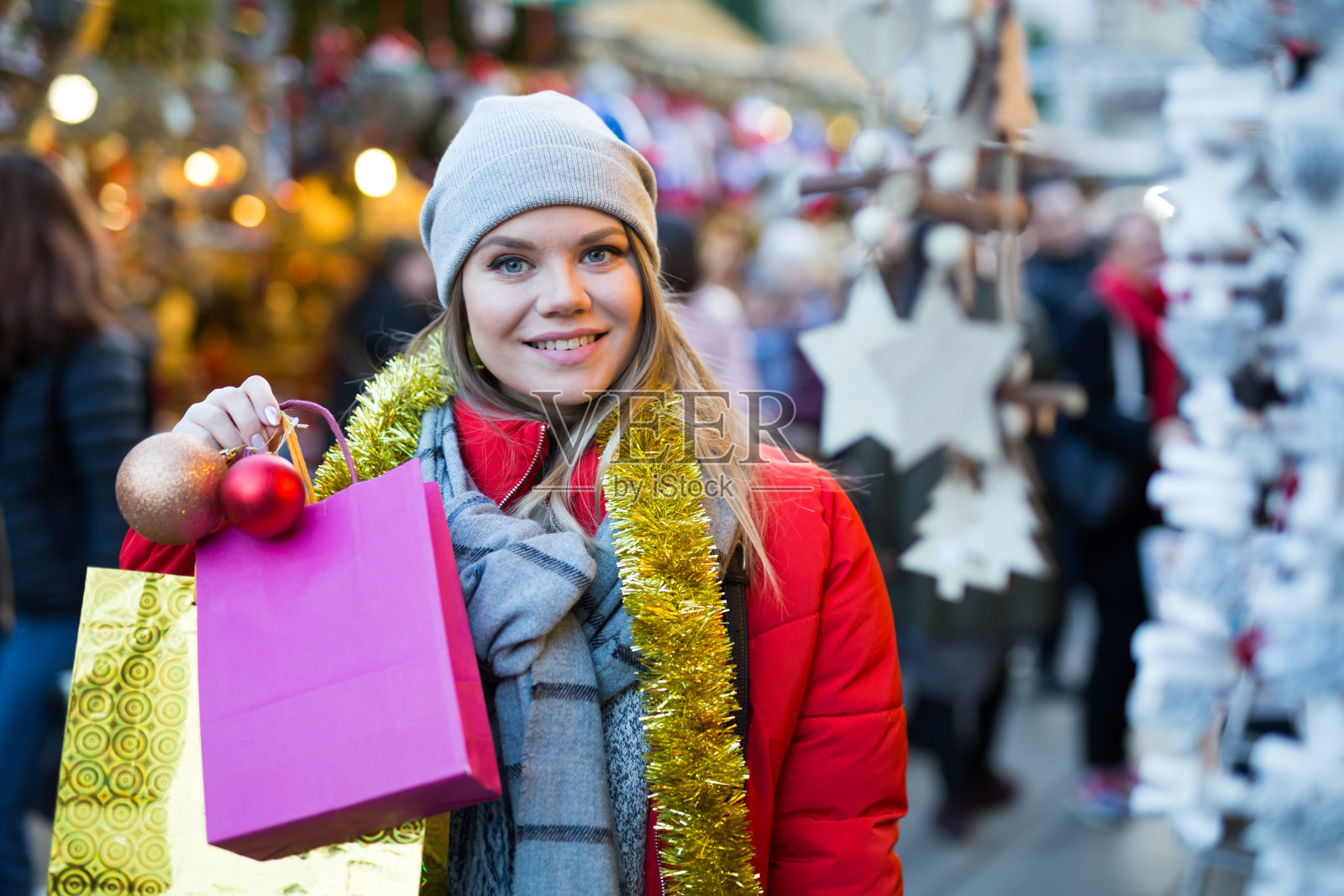 街边市场上,一名年轻女性在柜台旁买圣诞礼物照片摄影图片