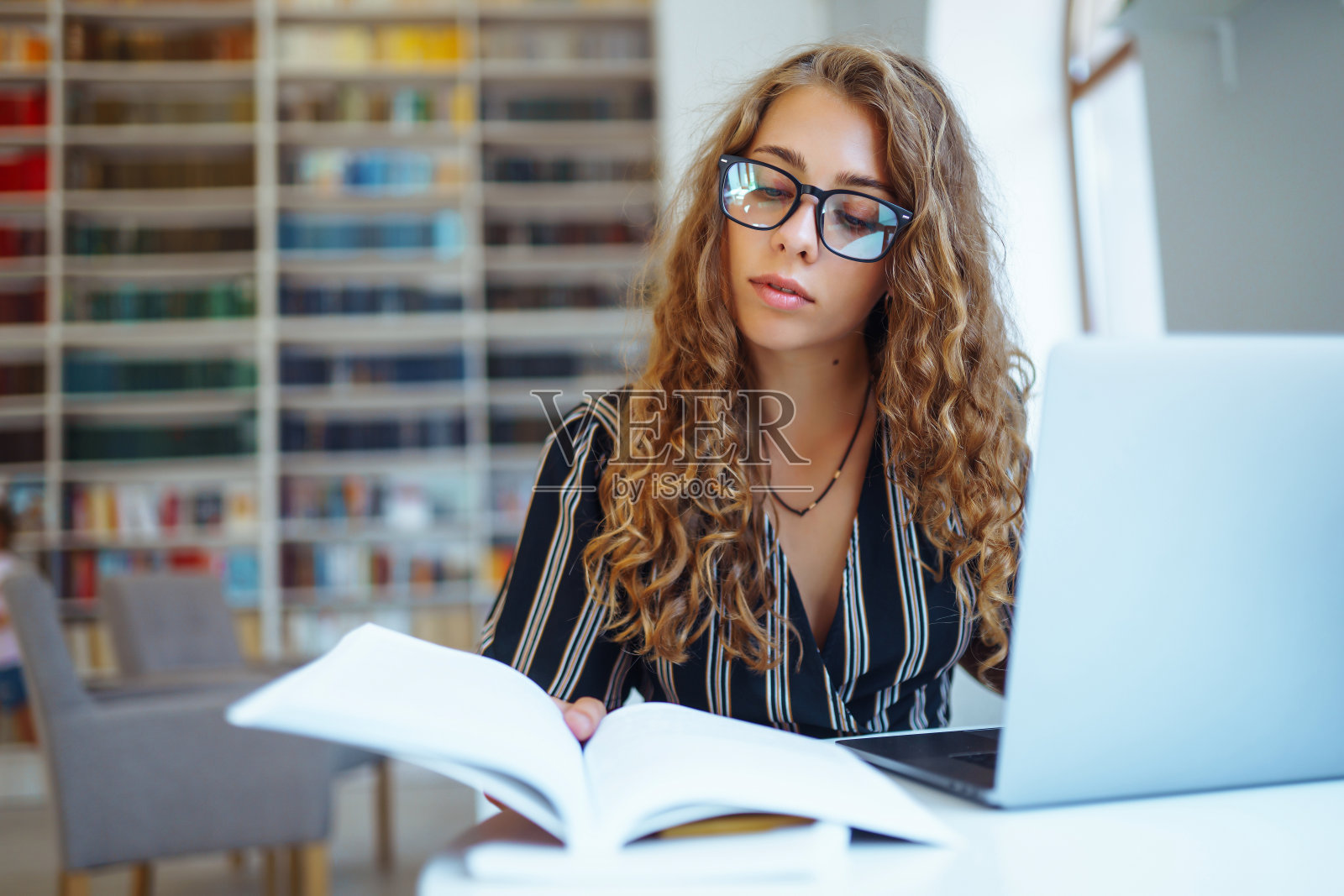 年轻女性在家里用笔记本电脑工作。照片摄影图片