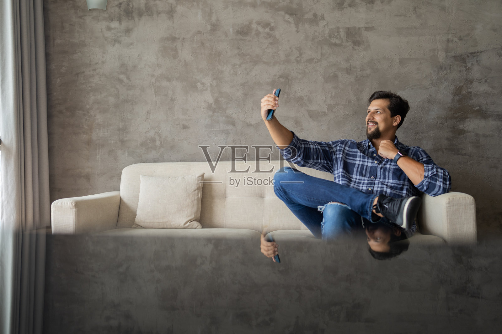 年轻的白人在家里用智能手机工作,通过视频电话开会。selife。照片摄影图片