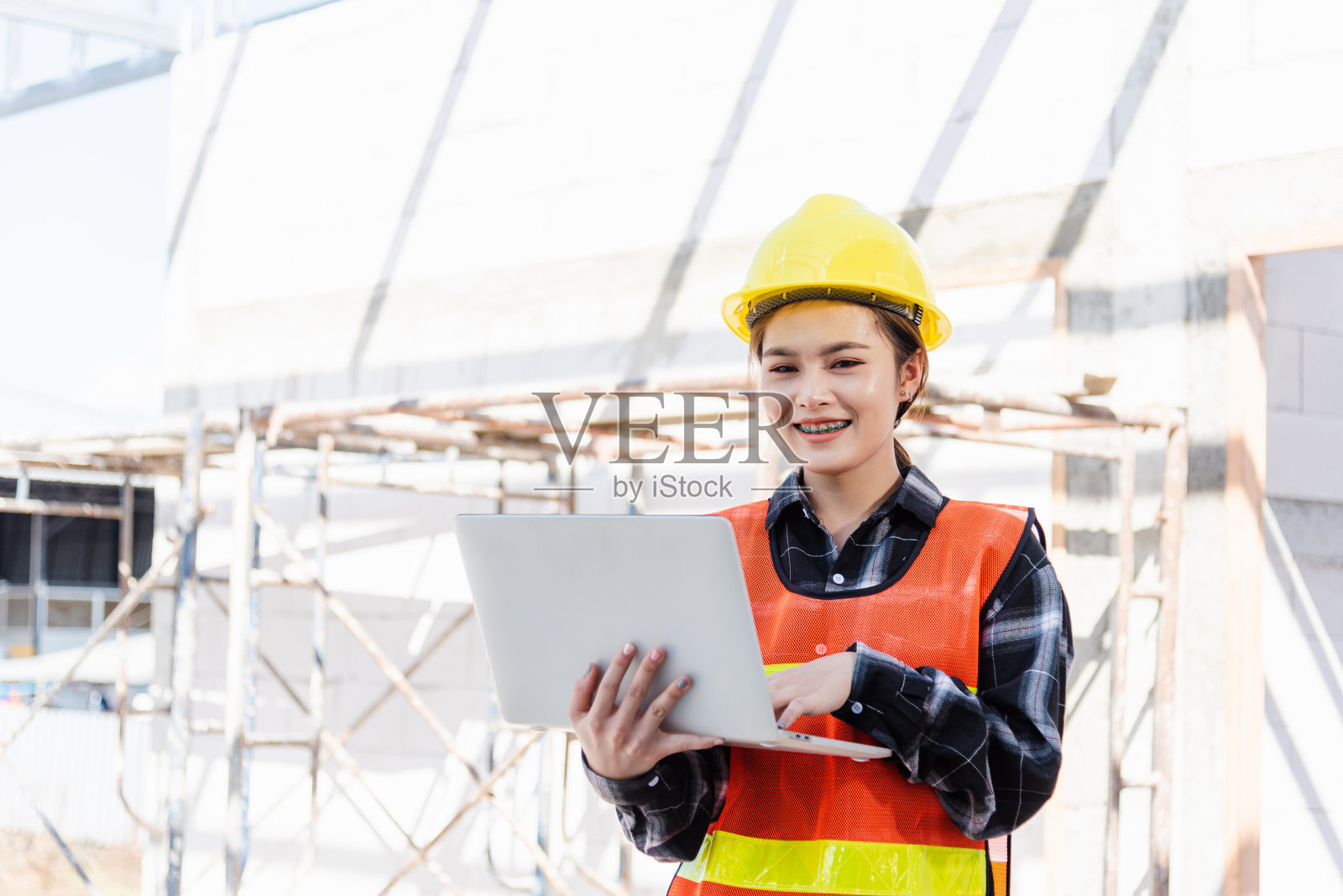 亚洲工程师,建筑师,工人,拿着笔记本电脑检查和监督建筑工地的基础设施进展照片摄影图片