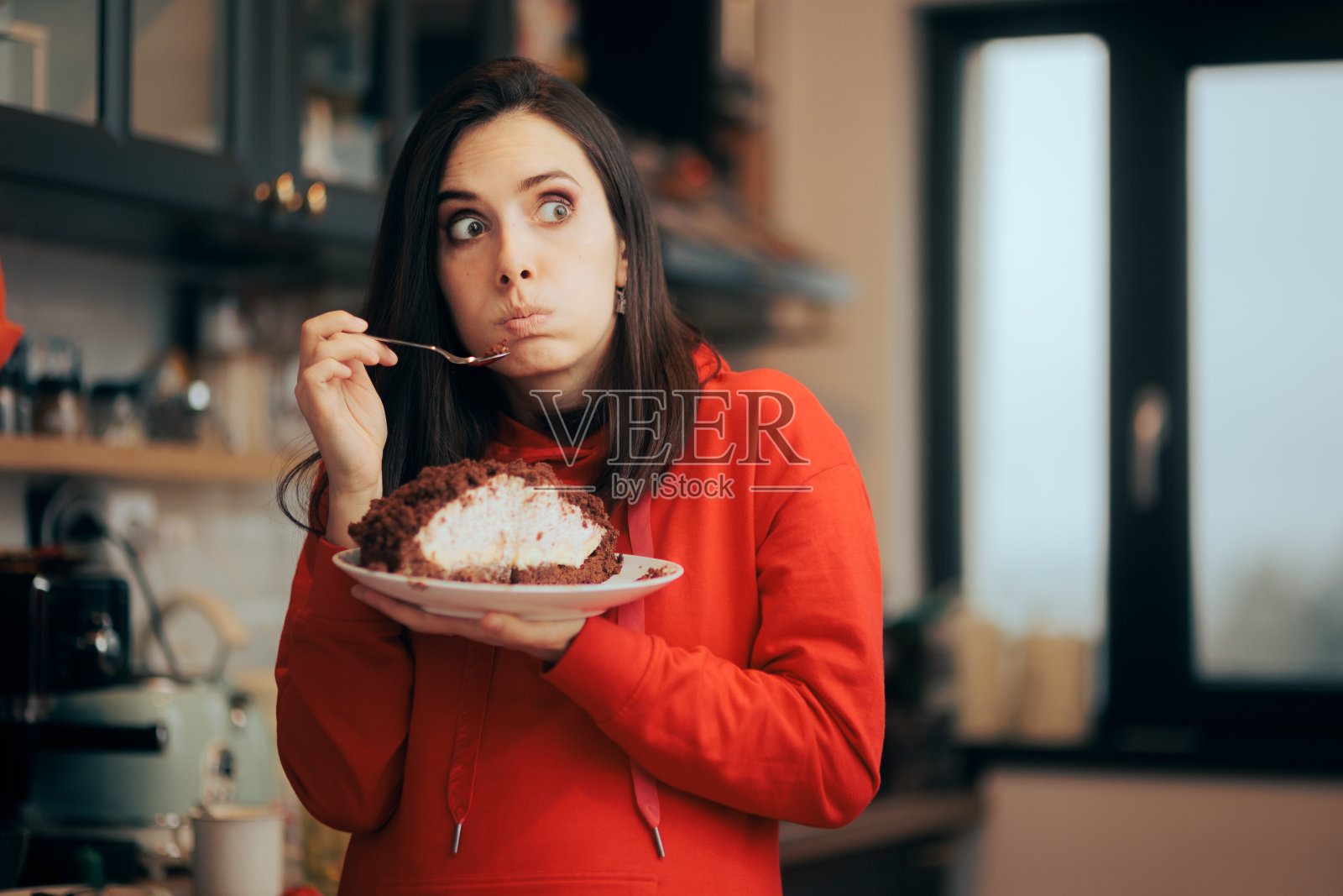 有趣的女人对吃蛋糕作弊饮食感到内疚照片摄影图片