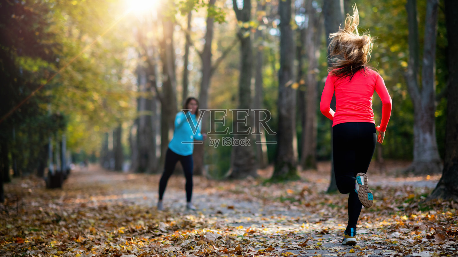 在公共公园和私人教练锻炼的女人。教练欢呼和女子跑步照片摄影图片