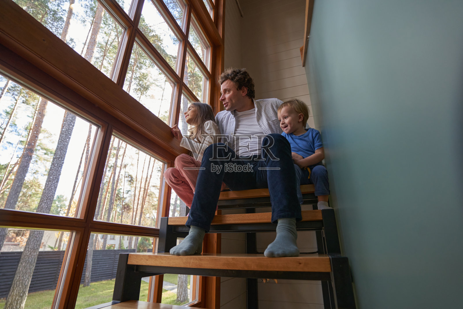 专心的孩子们一起看着窗户照片摄影图片