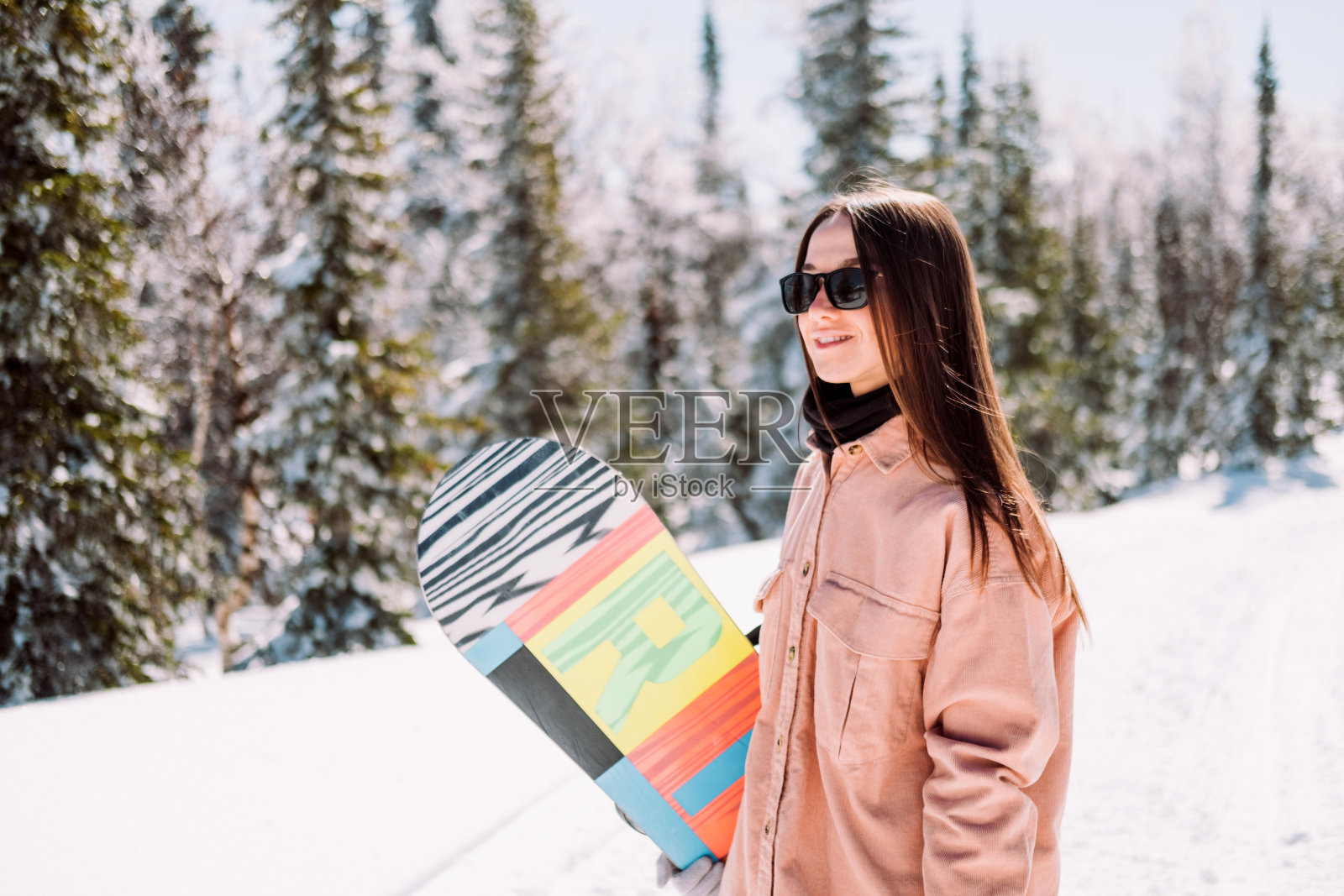 年轻的女孩滑雪板与一个滑雪板在自然的山在阳光明媚的天气照片摄影图片