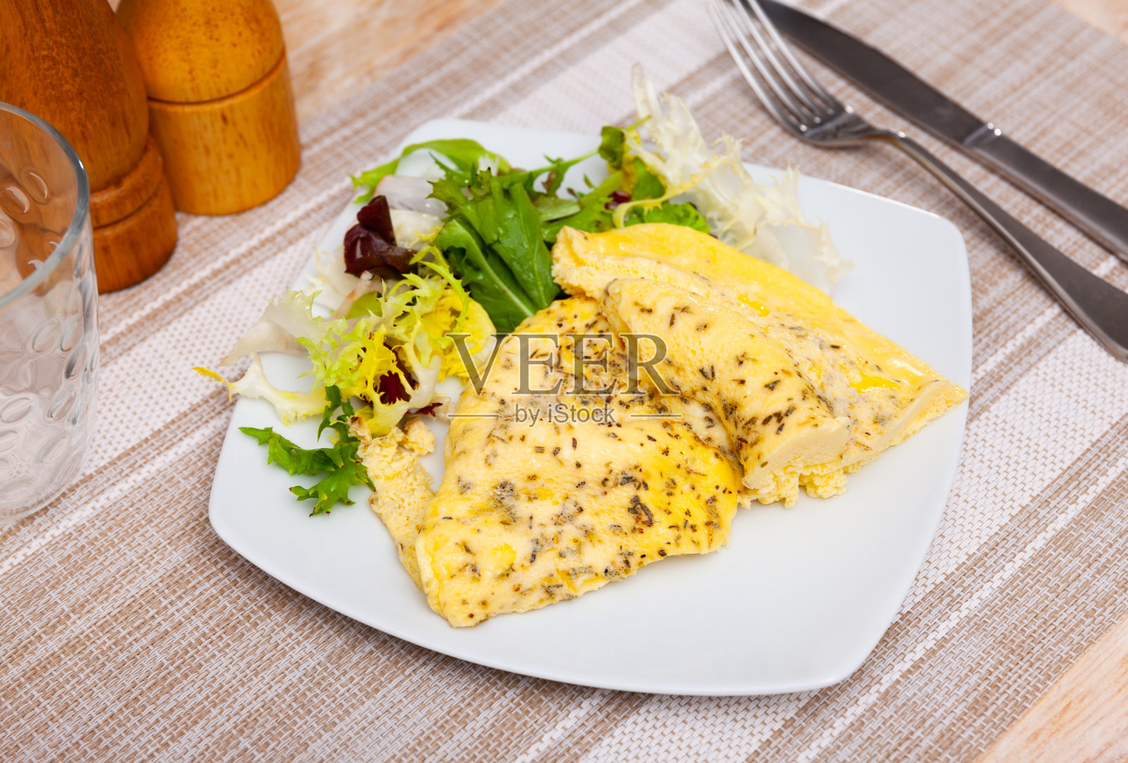 白色盘子里的煎蛋卷和芝麻菜。美味的早餐照片摄影图片