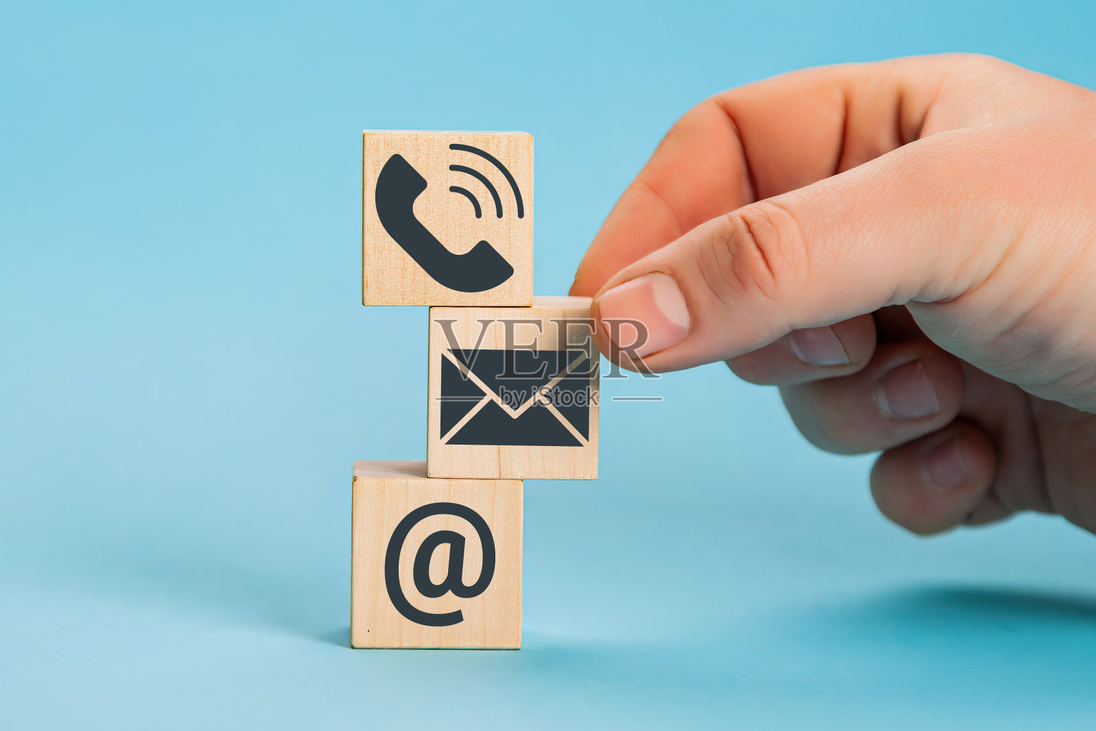 网站页面联系我们或电子邮件营销概念。手放木块立方体符号电话,电子邮件,地址照片摄影图片
