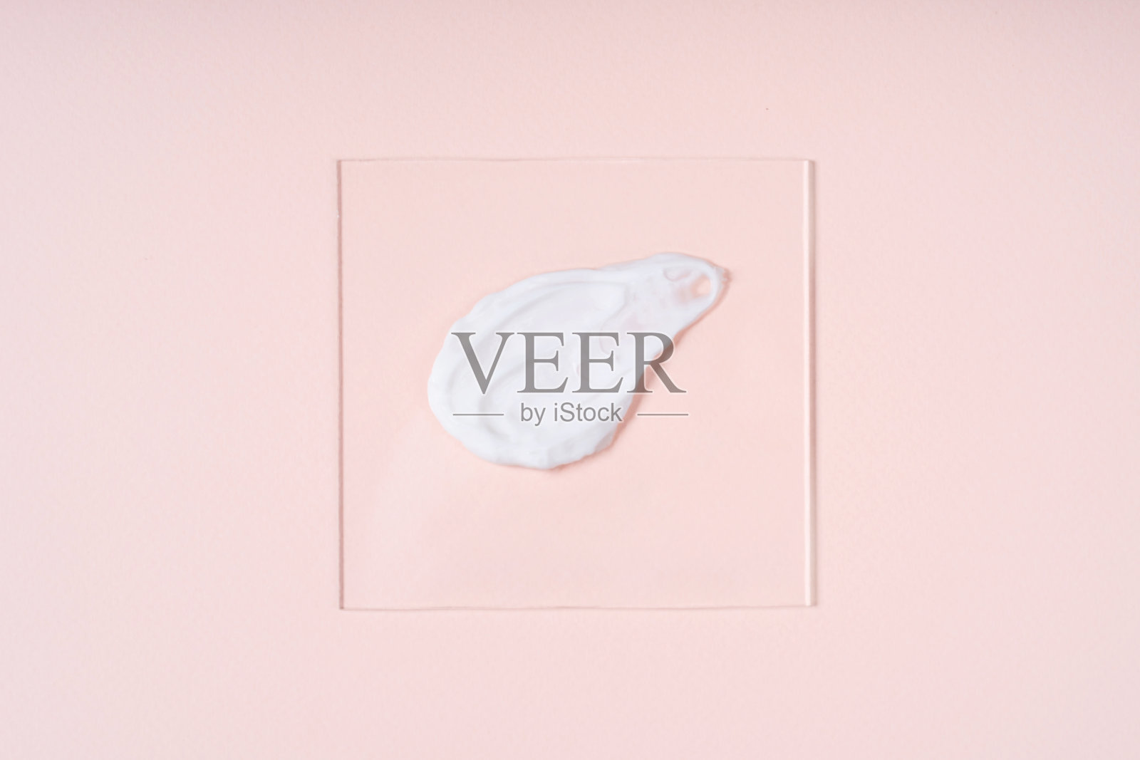 美丽的奶油涂抹在玻璃上的柔和的米色背景。化妆品实验室研究概念。照片摄影图片