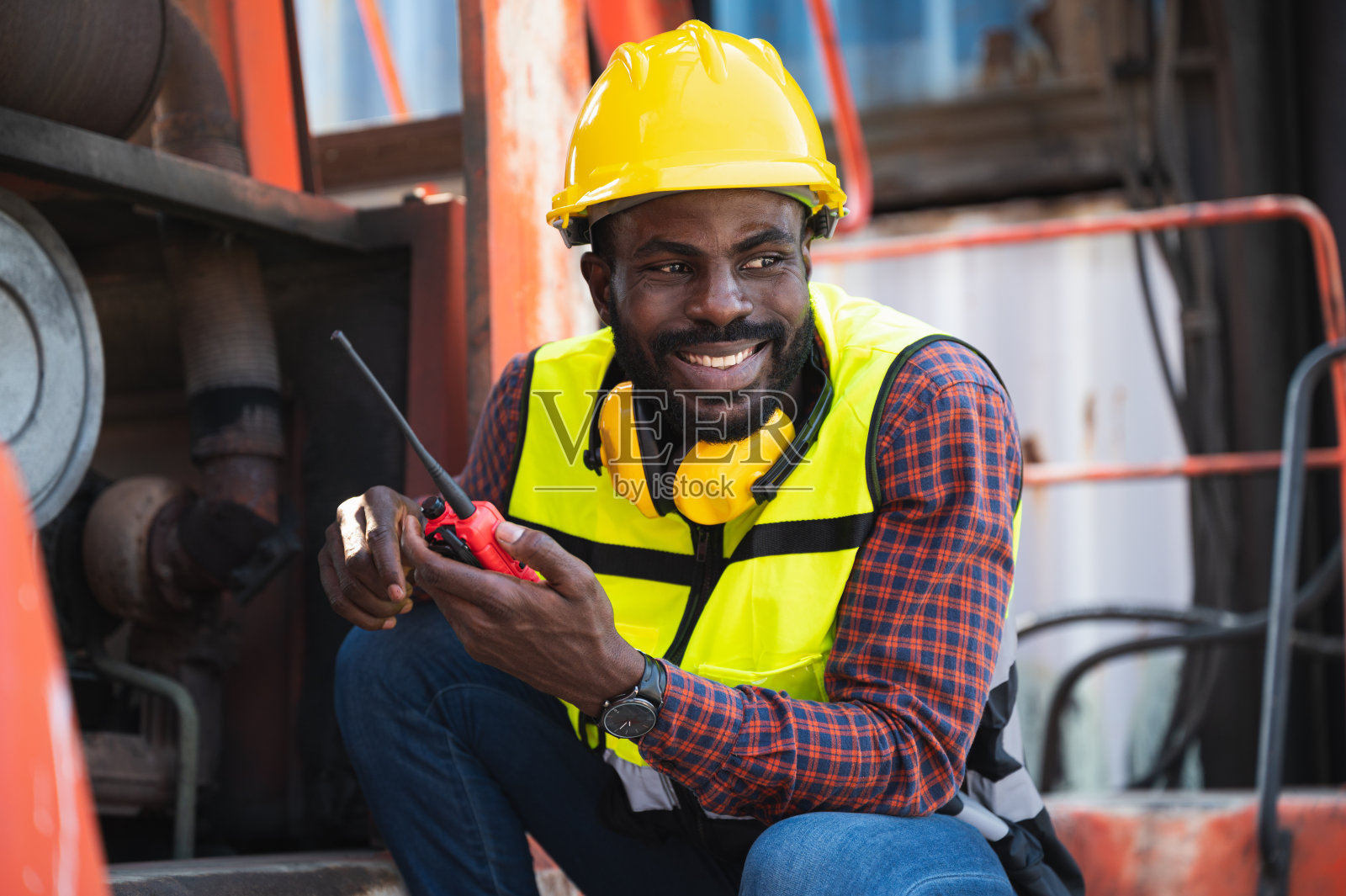 快乐的工头使用对讲机与机器背景照片摄影图片