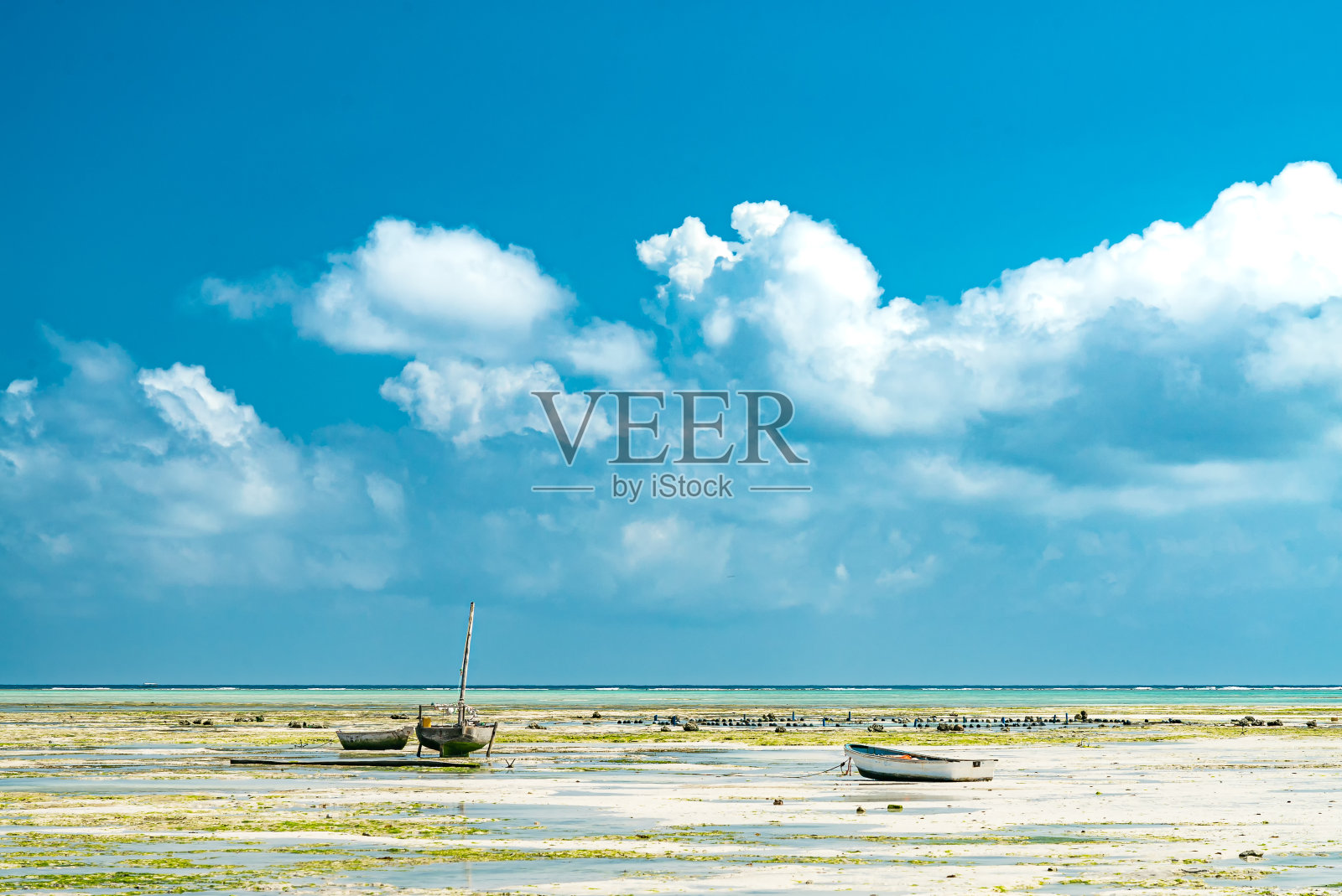 在坦桑尼亚桑给巴尔省的Nungwi,一艘船在退潮期间停靠在海滩上照片摄影图片