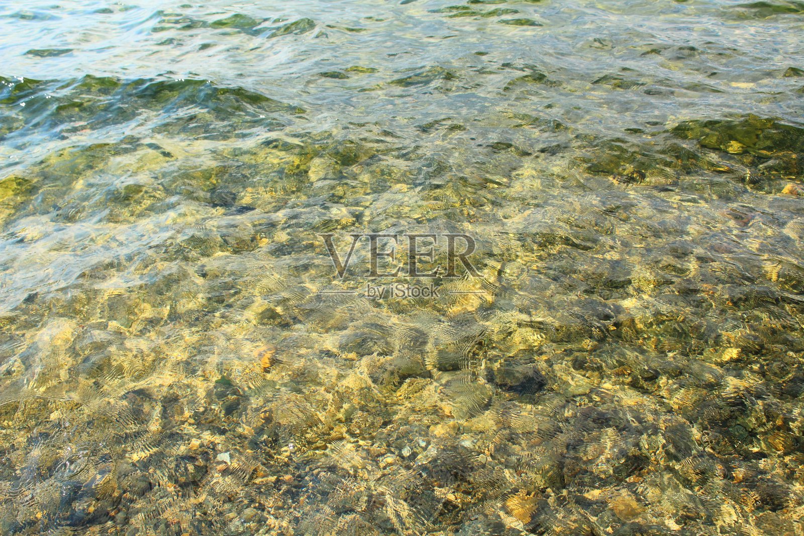 清澈见底的湖水和石头。背景。纹理。照片摄影图片