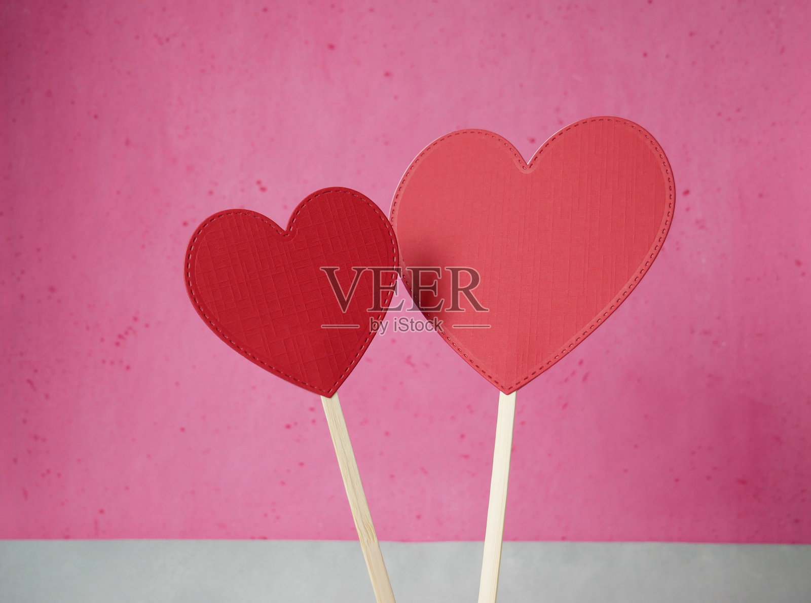 粉色和灰色背景上的红纸心照片摄影图片
