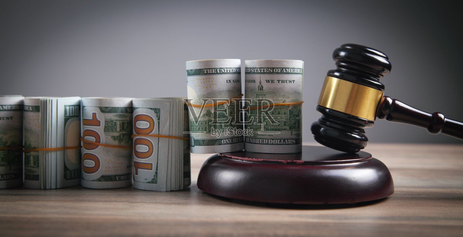 法官的木槌和金钱滚在木桌上。照片摄影图片