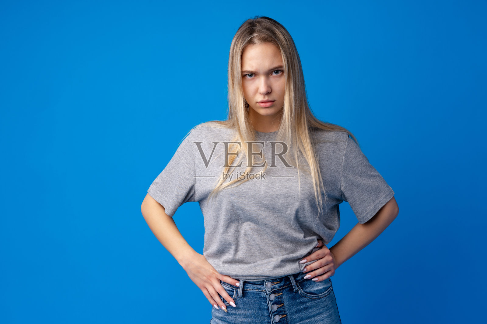 年轻少女的肖像不满不满的蓝色背景照片摄影图片