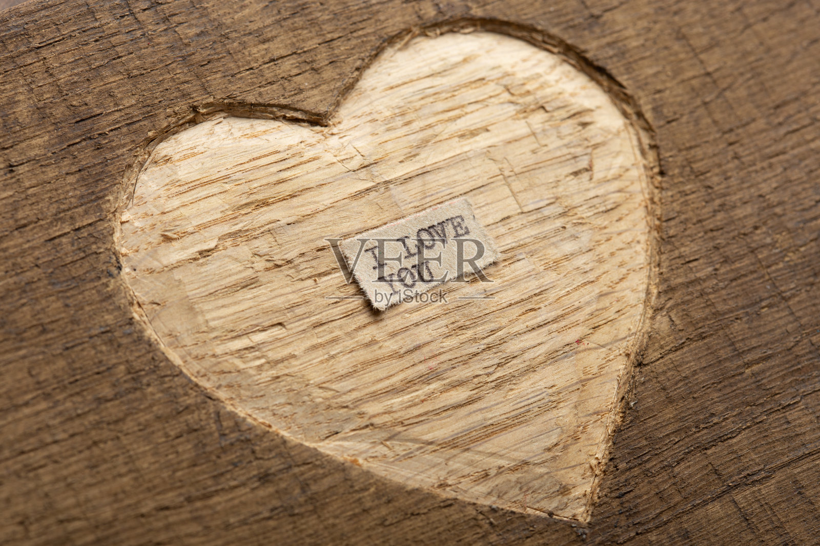 我爱你-微小的打字笔记关闭。情人节问候概念。在木头上雕刻心形作为情人节贺卡的背景。照片摄影图片