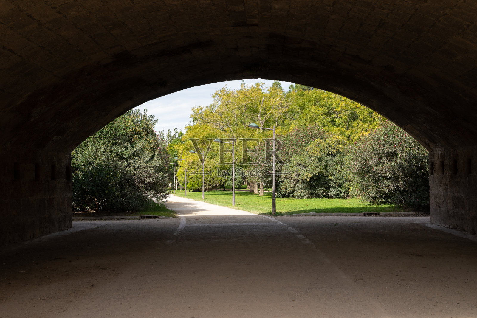 古老的石桥横跨古老的河床,城市公园。西班牙巴伦西亚图里亚河的雷亚尔河照片摄影图片