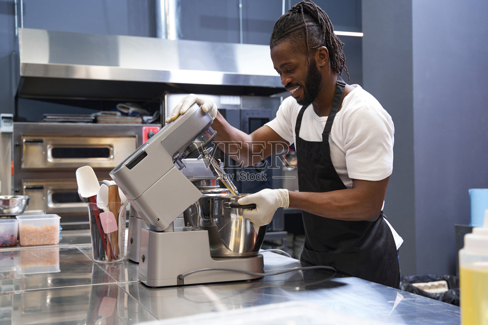 微笑的男人在厨房里做面团照片摄影图片