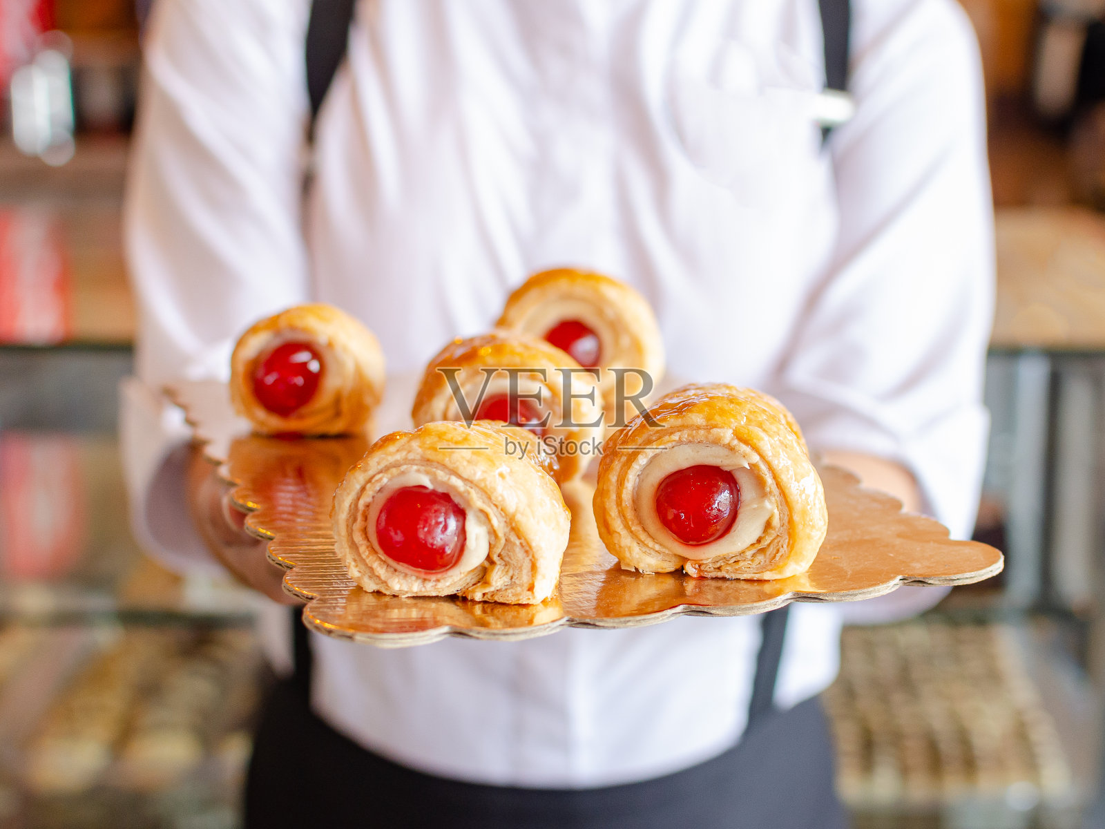 甜馅煎饼卷配酸樱桃,由女孩端上来照片摄影图片