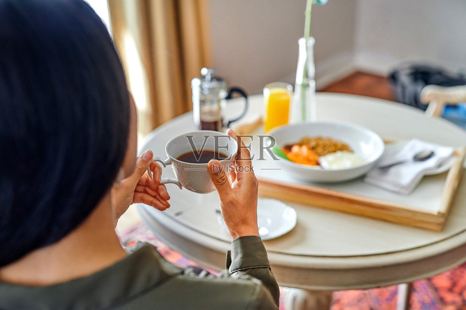 这张照片拍摄的是一个不认识的女人,早上独自坐在酒店房间里喝咖啡照片摄影图片