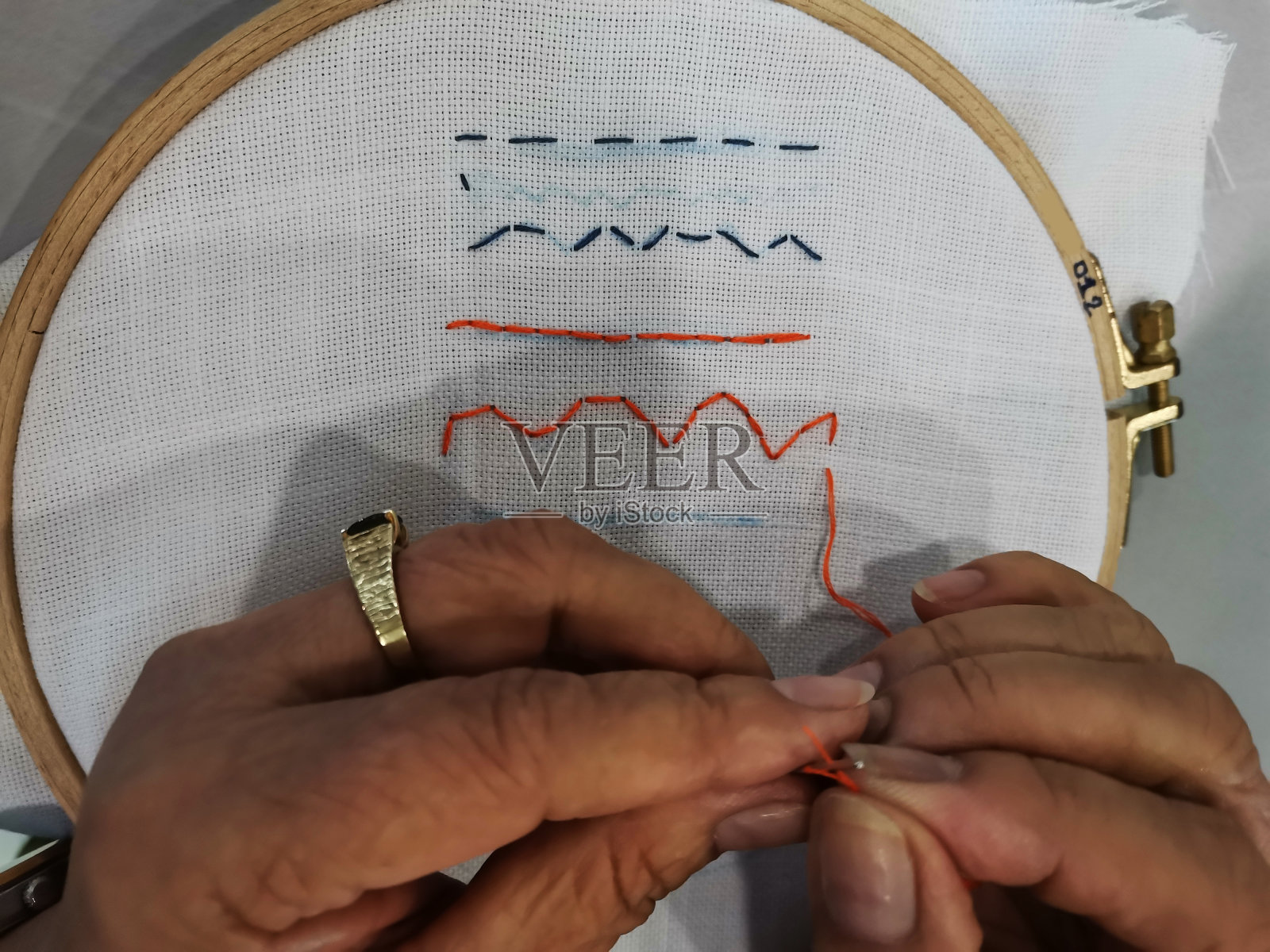 泰国妇女在泰国曼谷的工作室学习艺术手工艺课程,在专业教师的指导下使用工具设备用针织纱线在棉织物上手工刺绣照片摄影图片