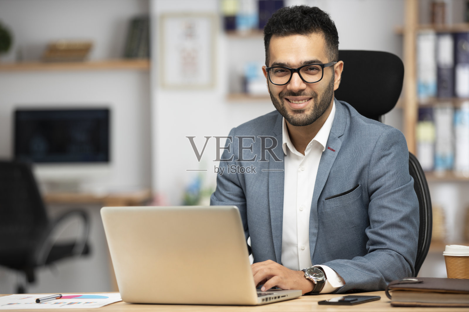 一个英俊的年轻商人在办公室工作的肖像照片摄影图片