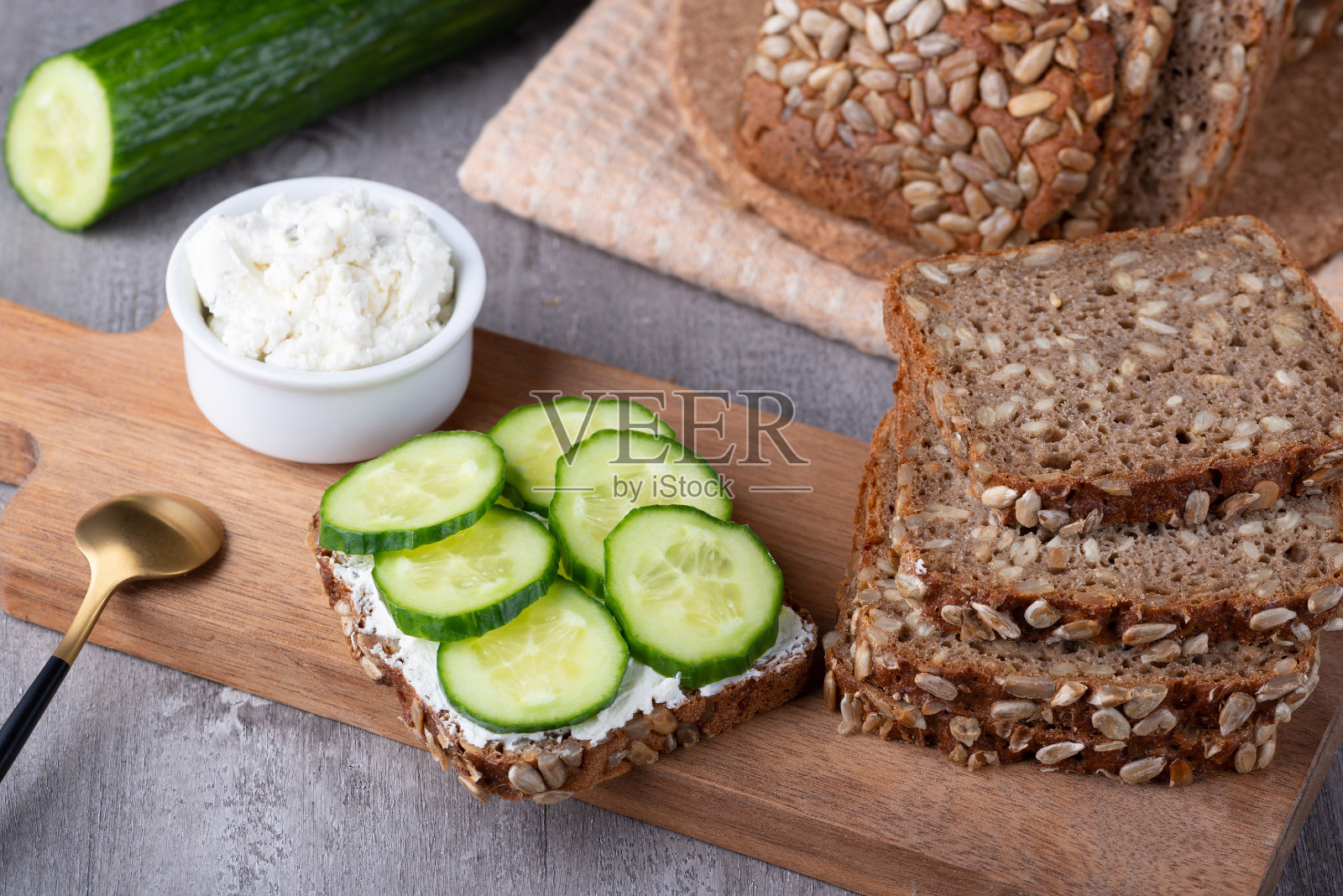 黑麦面包片与白软干酪和黄瓜在灰色背景上照片摄影图片