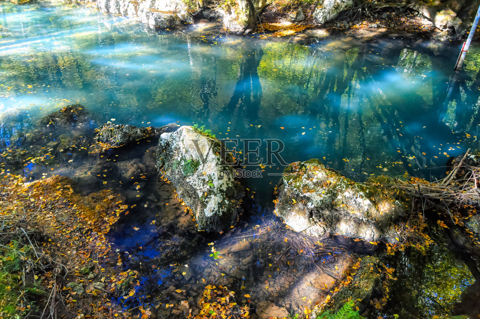 平静的翡翠绿色的水,山河经过。照片摄影图片