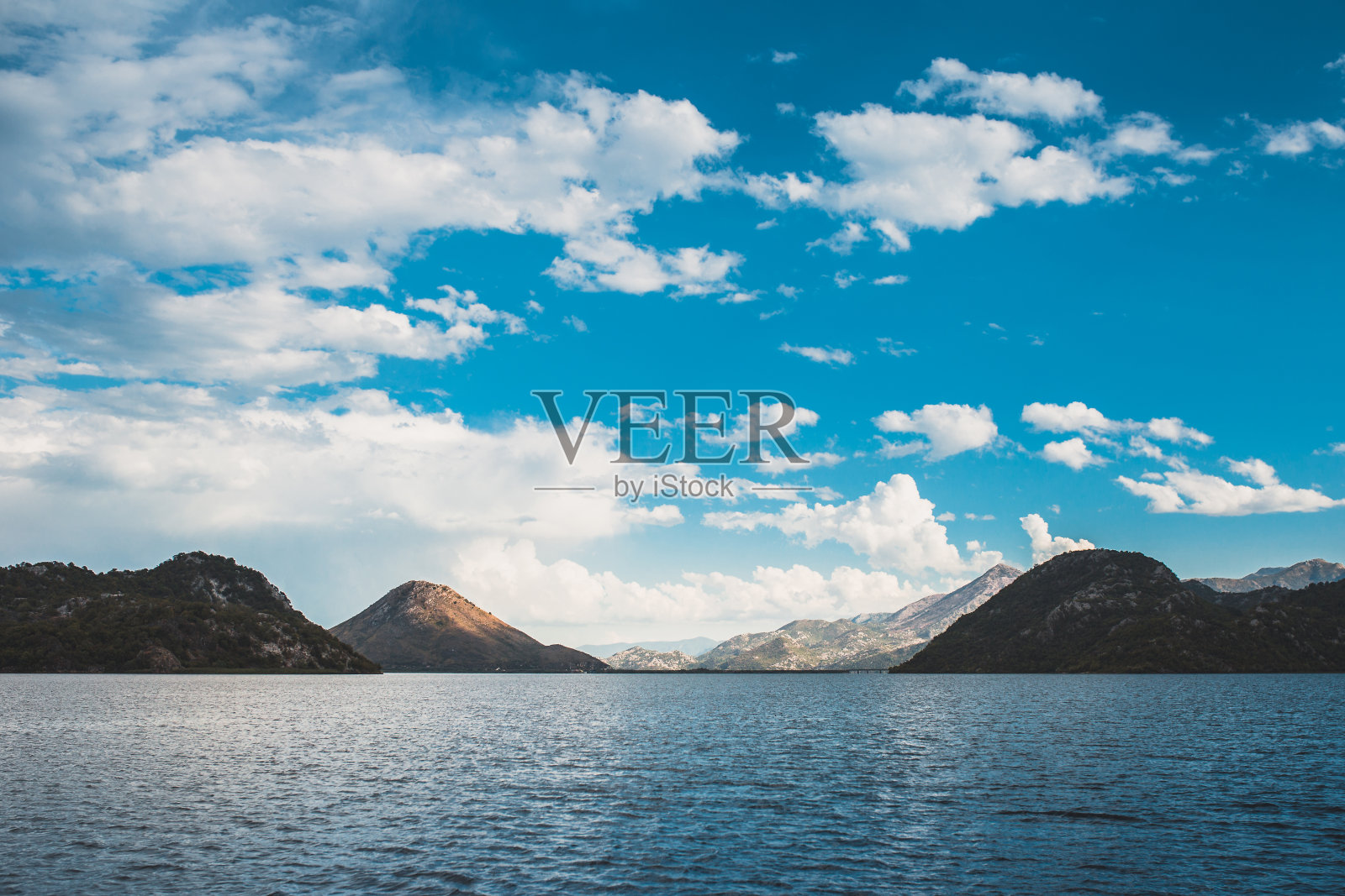 从水中可以看到令人叹为观止的山景和水生植物照片摄影图片