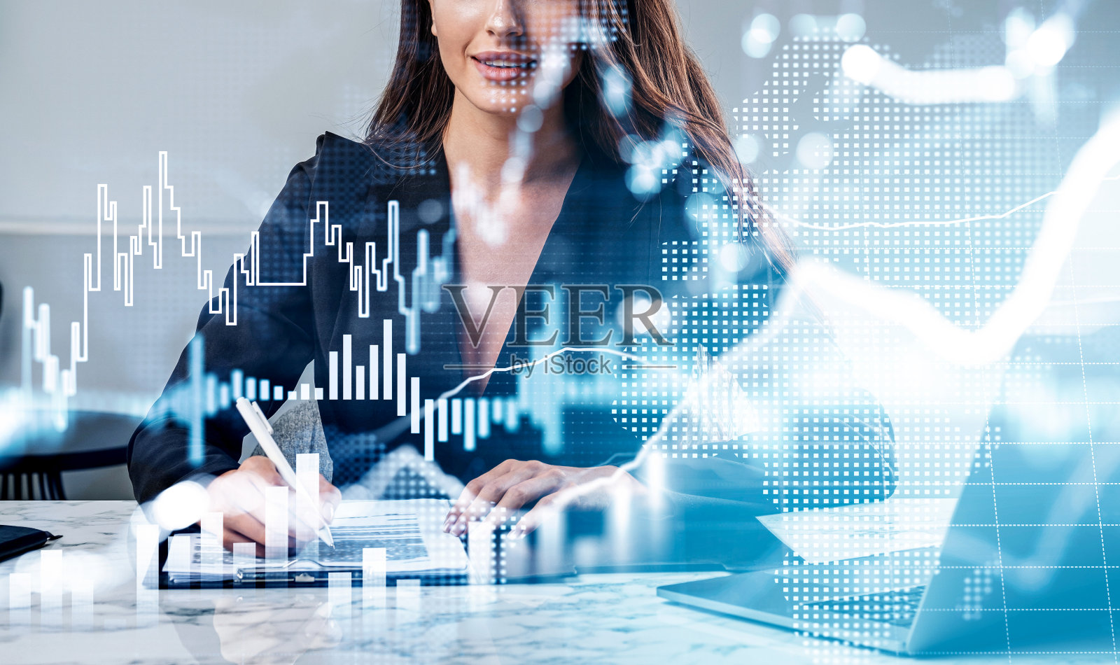 穿着西装的女商人在笔记本电脑上工作并做笔记照片摄影图片