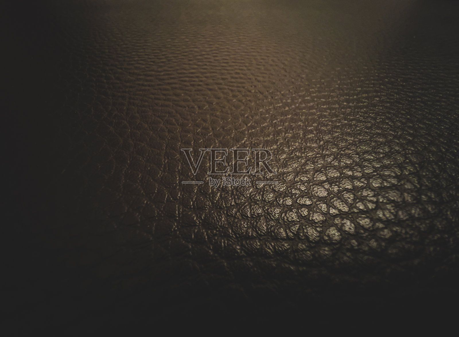 带有图案的深棕色皮革的微距图片。照片摄影图片