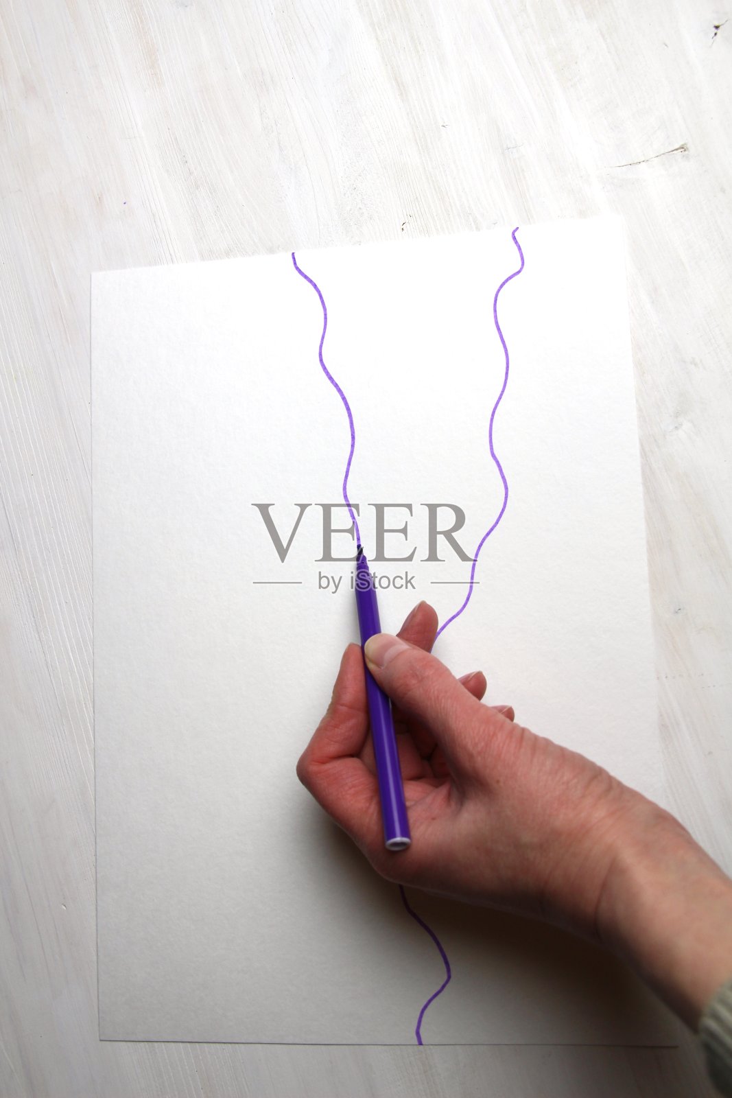 用紫色记号笔和随意的波浪线在白纸上手绘照片摄影图片