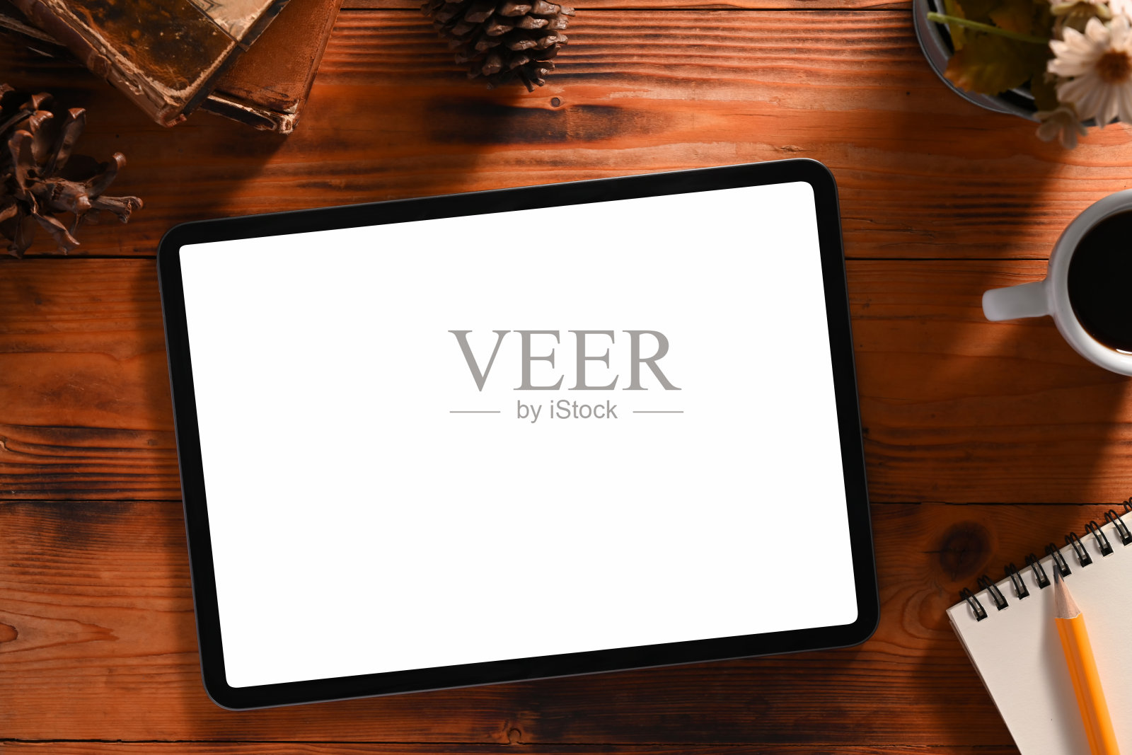 模拟数字平板电脑与空屏幕,书,蜡烛和松果木制背景。照片摄影图片