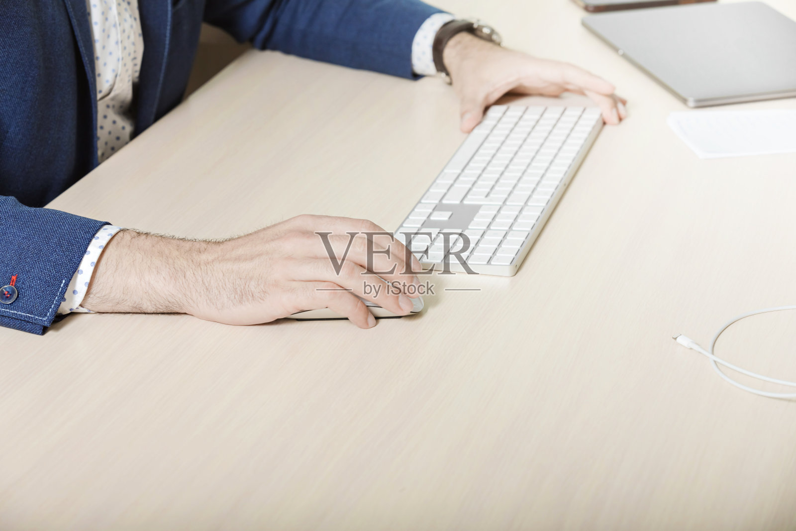 一个商人的手正在轻木桌背景上的键盘上打字。网上经营理念,金融家的工作。照片摄影图片