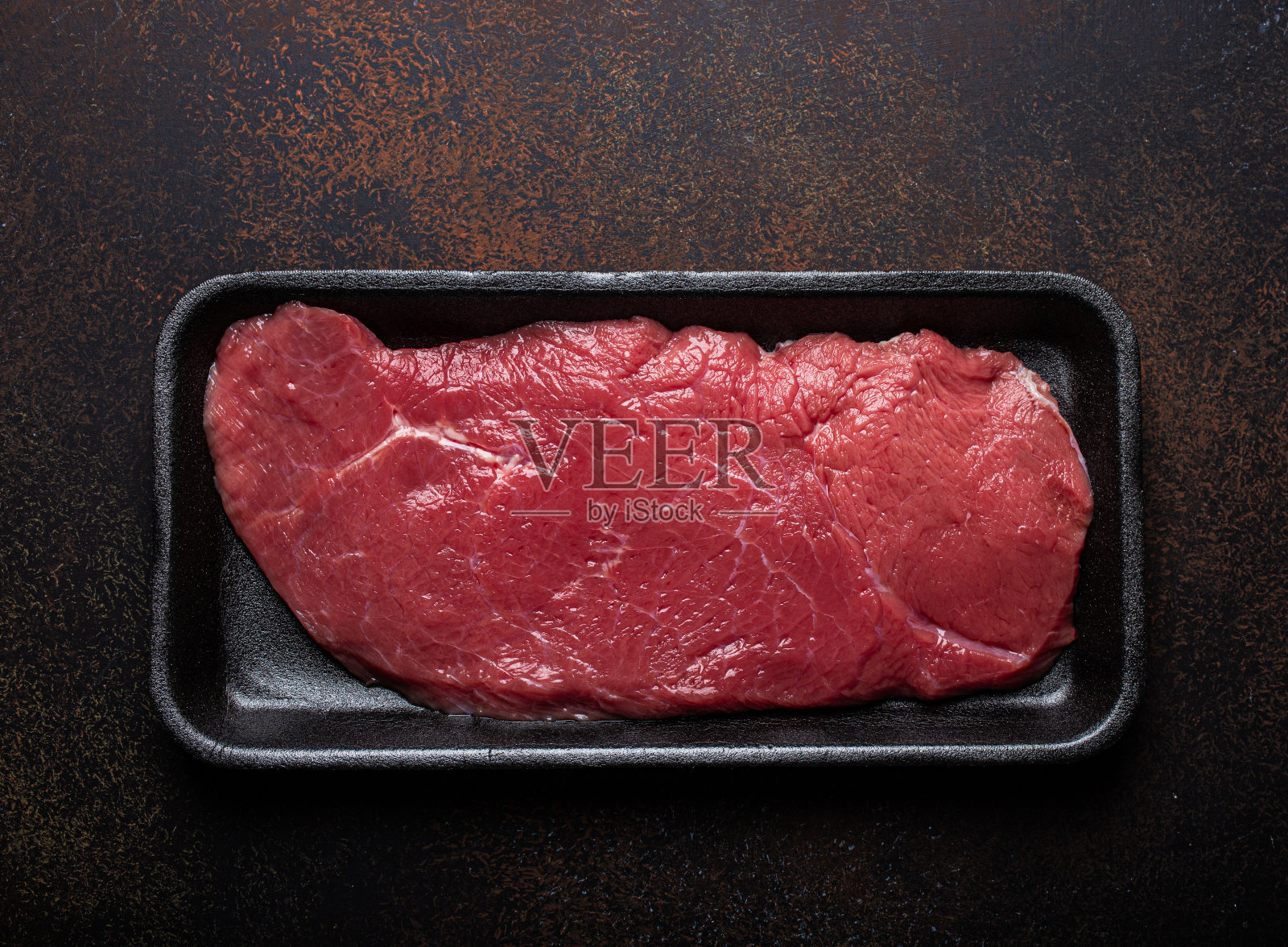 牛肉精瘦生菲力牛排在黑色塑料容器照片摄影图片