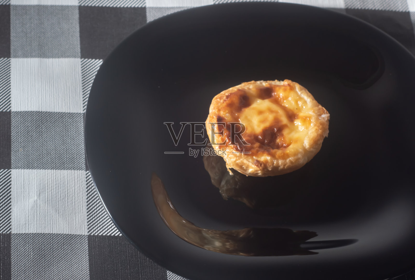 巴西和葡萄牙的传统甜点,名字为“纳塔粉彩”或“贝伦粉彩”,印在一个黑色盘子上,左边是复制空间照片摄影图片