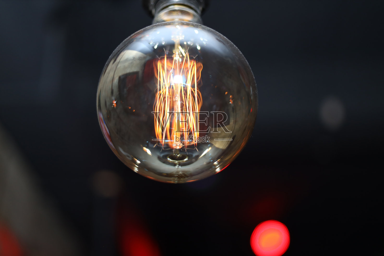 白炽灯灯丝特写,选择性聚焦。发光的爱迪生灯泡在黑色背景上照片摄影图片