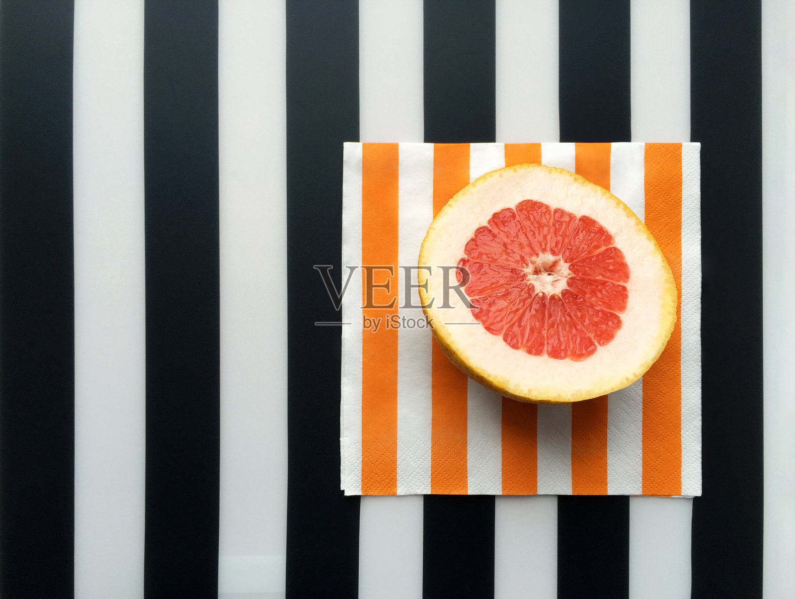 条纹背景上的葡萄柚片照片摄影图片