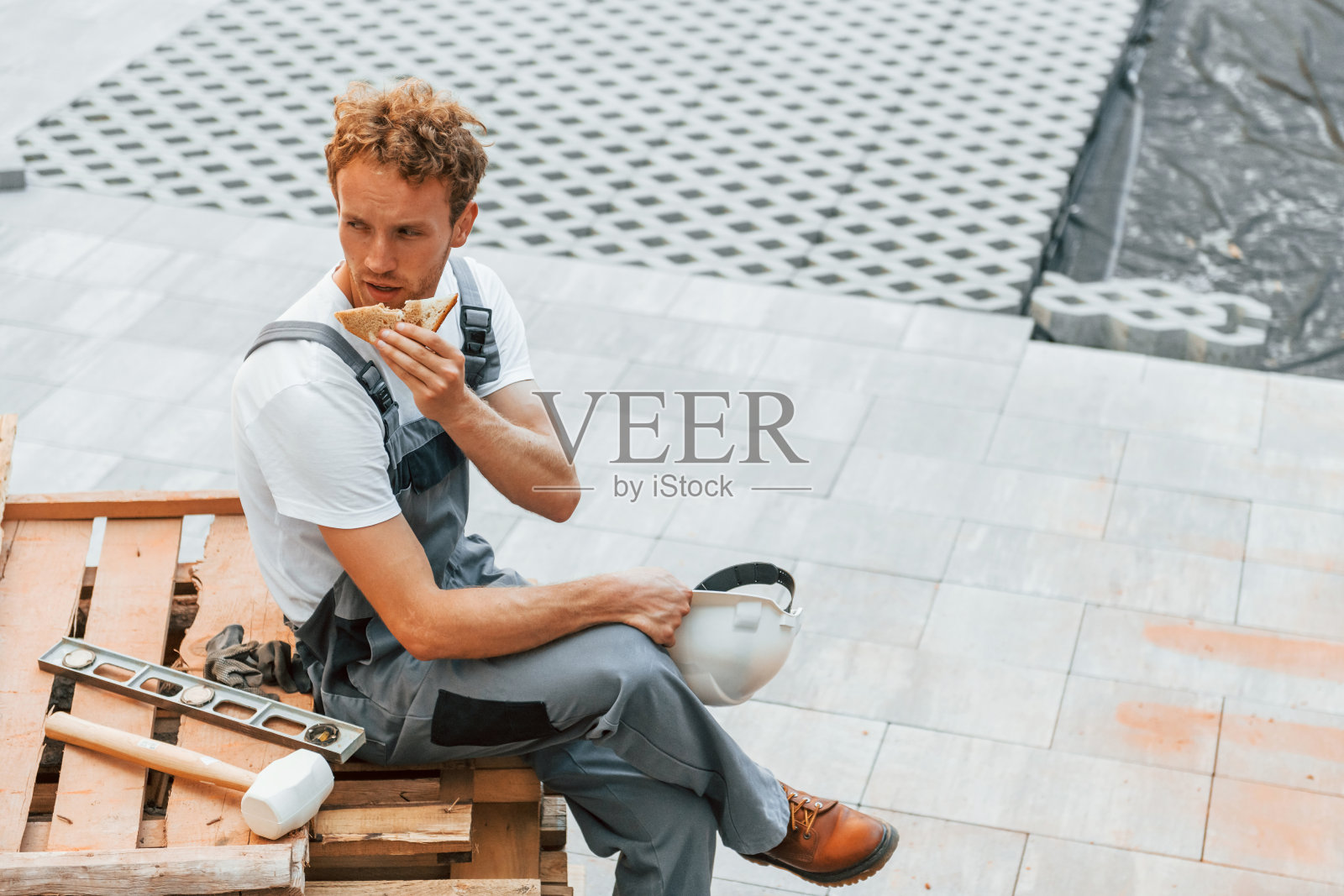 灰色的颜色的衣服。白天穿制服在工地工作的年轻人照片摄影图片