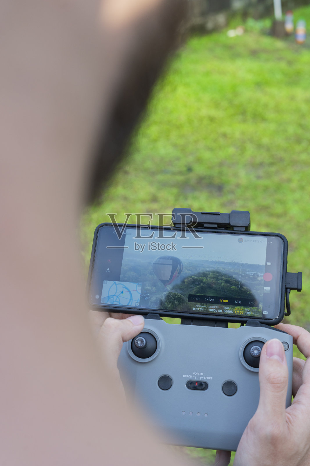 一名男子从上方驾驶无人机,从屏幕上观看它照片摄影图片