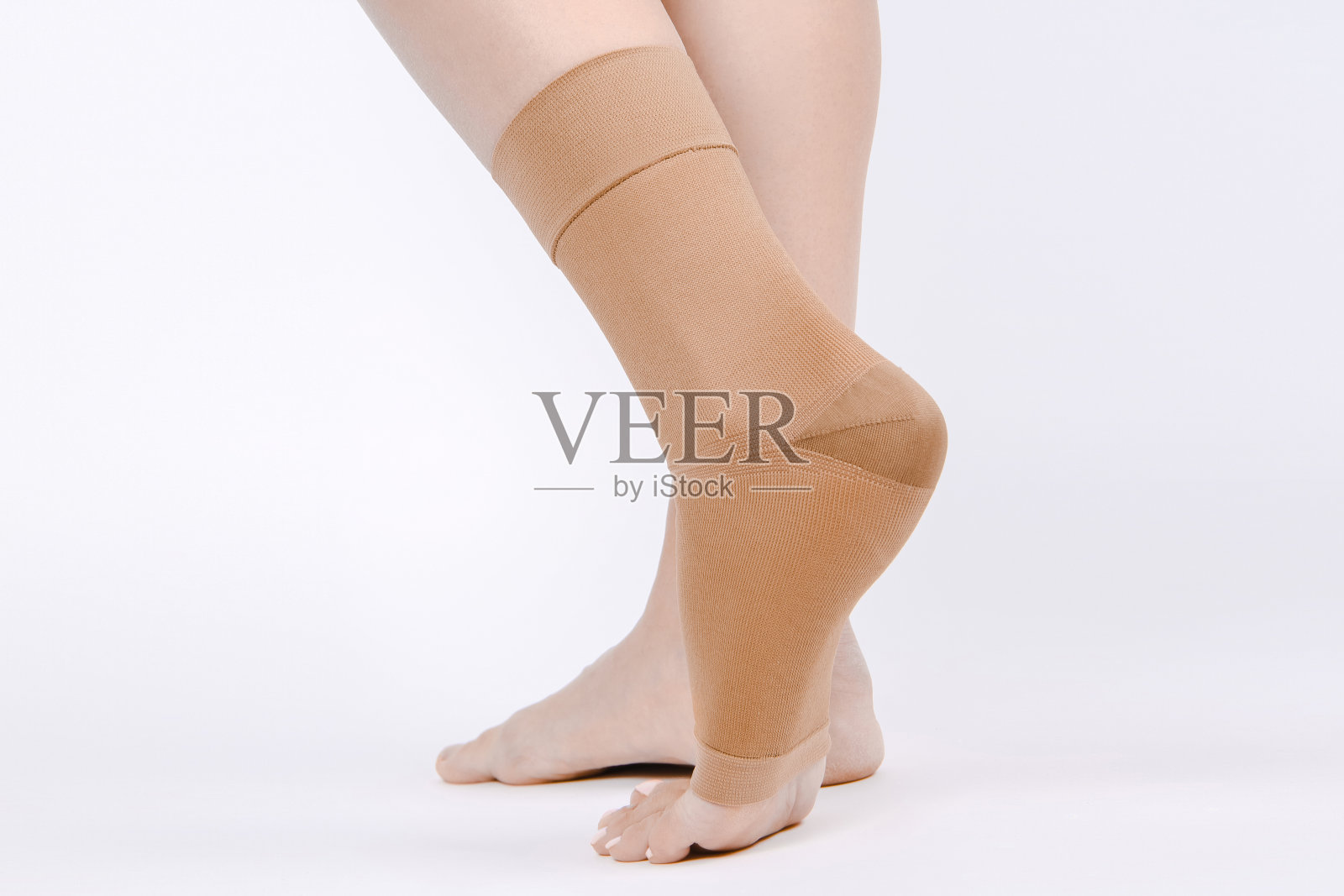 骨科脚踝支撑。医疗脚踝的绷带。医疗踝关节支持带可调节包裹绷带支撑脚疼痛缓解运动。腿支撑孤立在白色背景上。创伤踝关节矫正法。受伤照片摄影图片