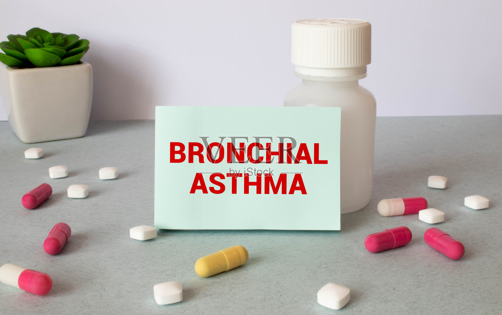 在笔记本上是支气管哮喘的文字,旁边有听诊器、药片和眼镜照片摄影图片