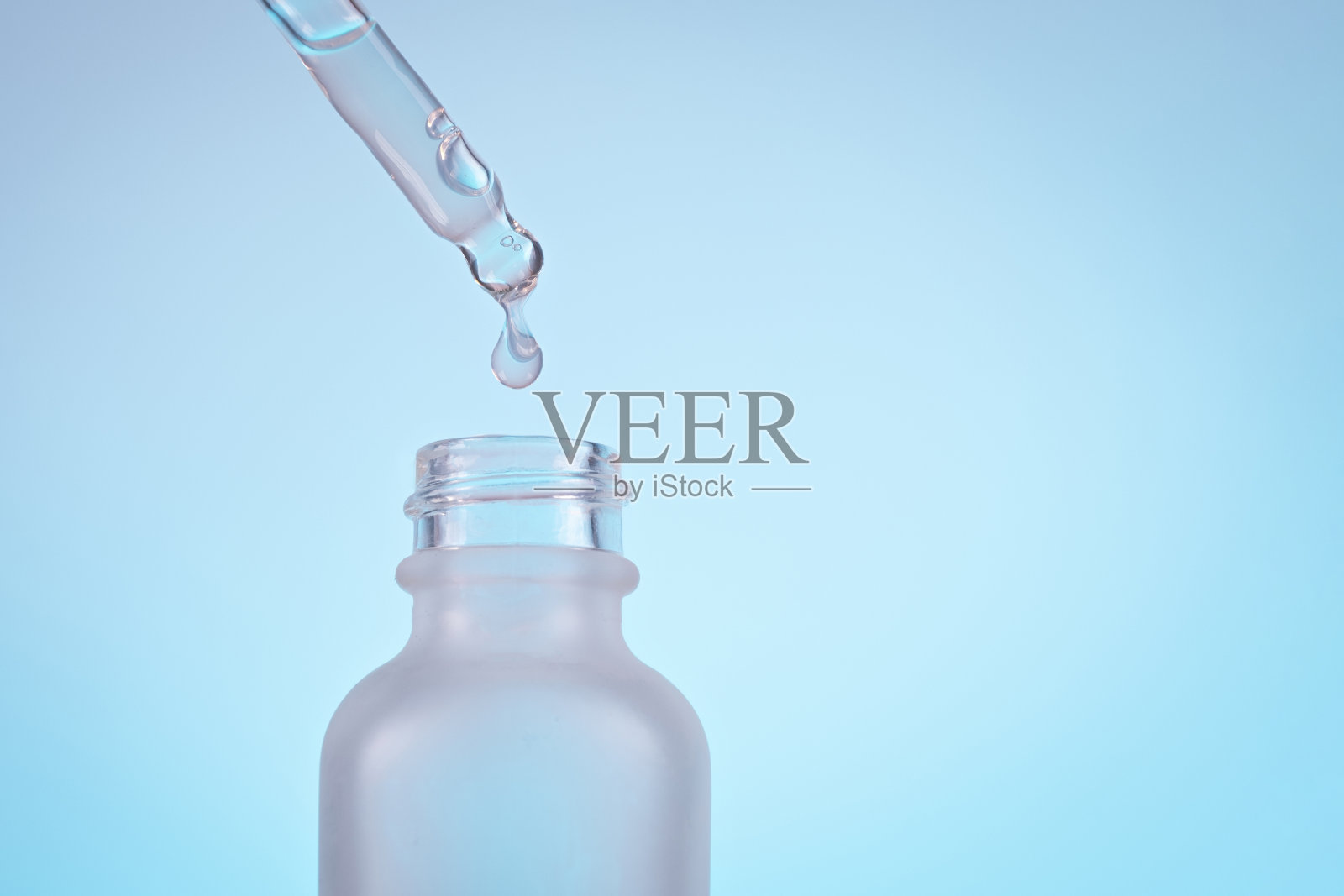 脸血清油滴与滴管玻璃瓶移液在蓝色背景上接近照片摄影图片