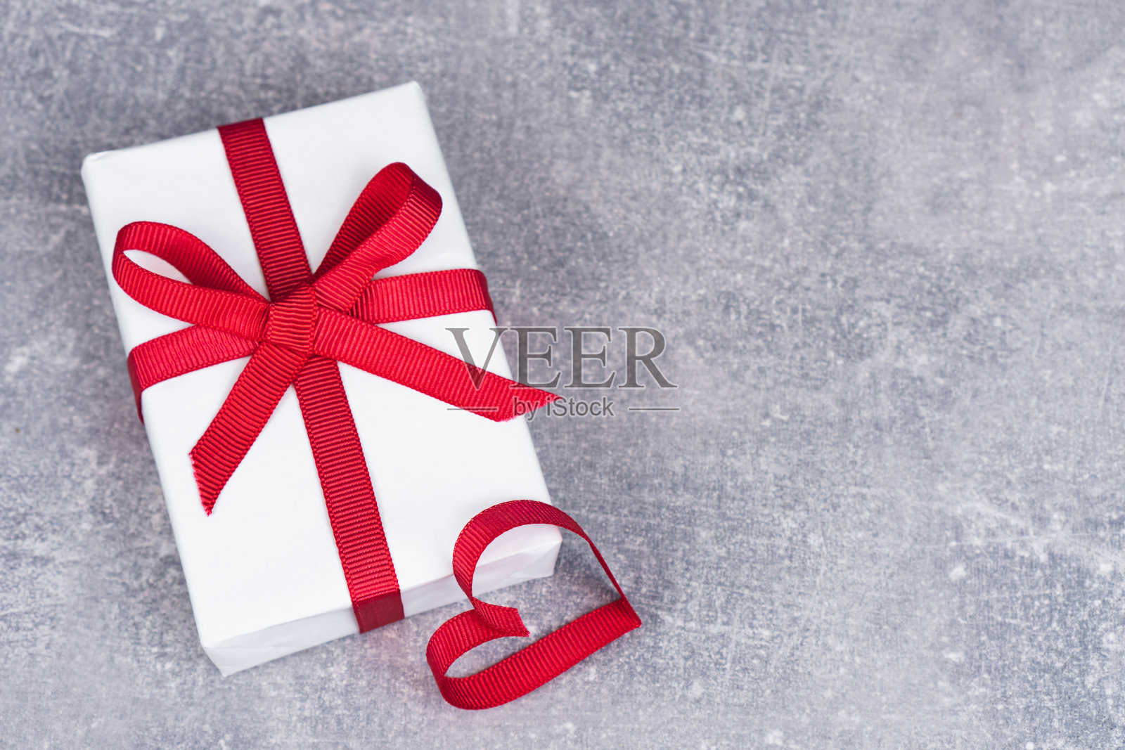 情人节或生日的概念与复制空间。灰色背景上的红丝带心和礼盒照片摄影图片